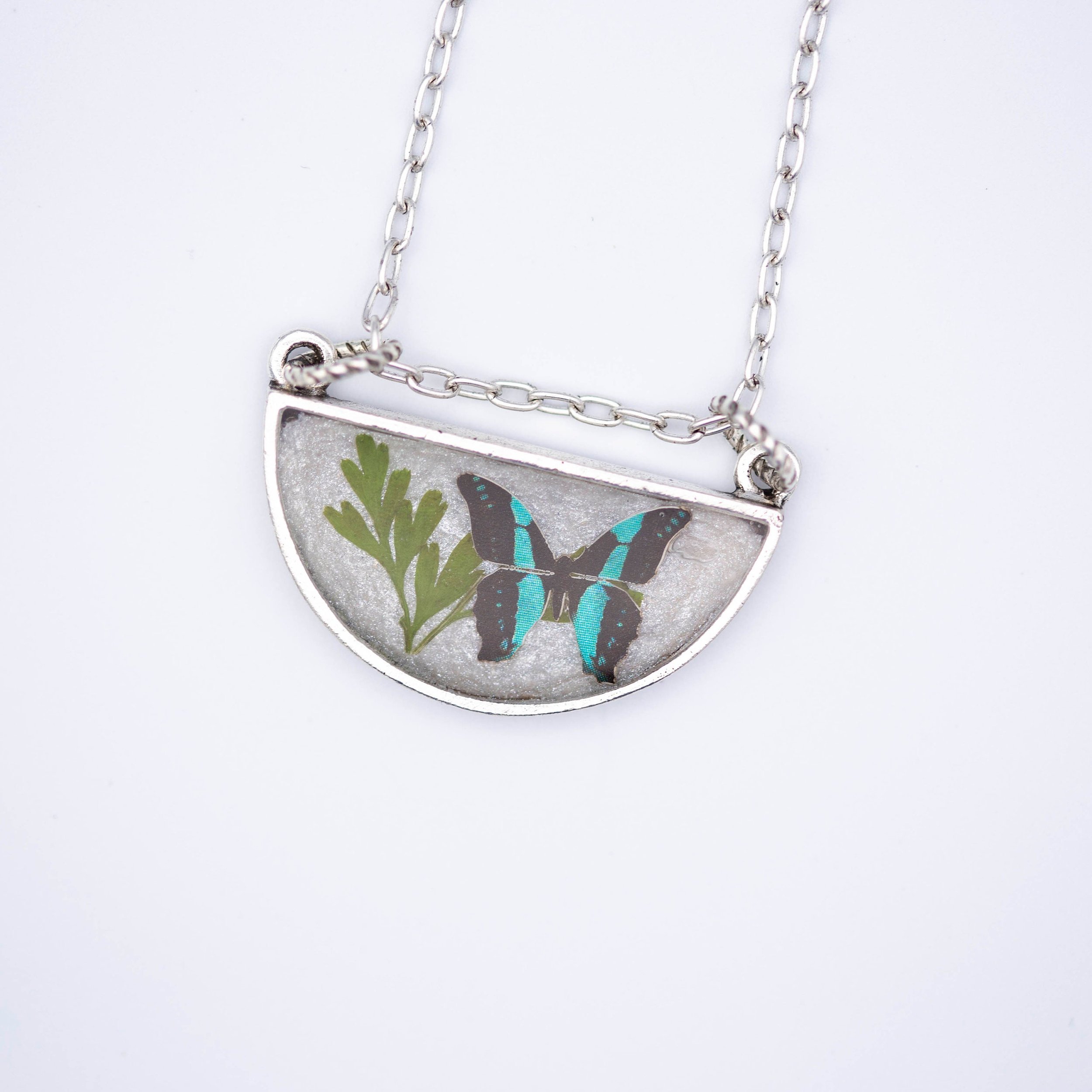 Antique silver necklace with half-circle pendant of real pressed leaf, bluebottle butterfly design, & smoky quartz gemstone in resin on a fine silver cable chain - appreciate the beauty of nature.