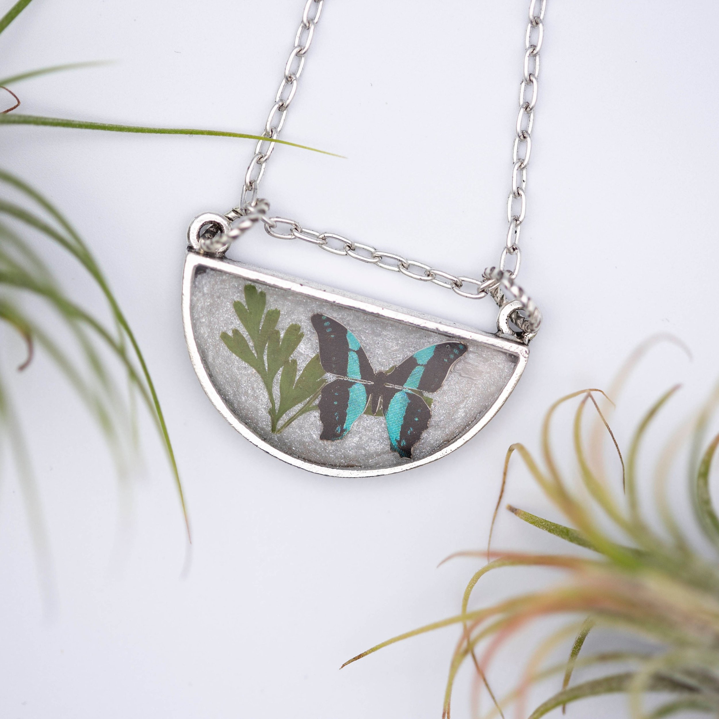 Antique silver necklace with half-circle pendant of real pressed leaf, bluebottle butterfly design, & smoky quartz gemstone in resin on a fine silver cable chain - appreciate the beauty of nature.