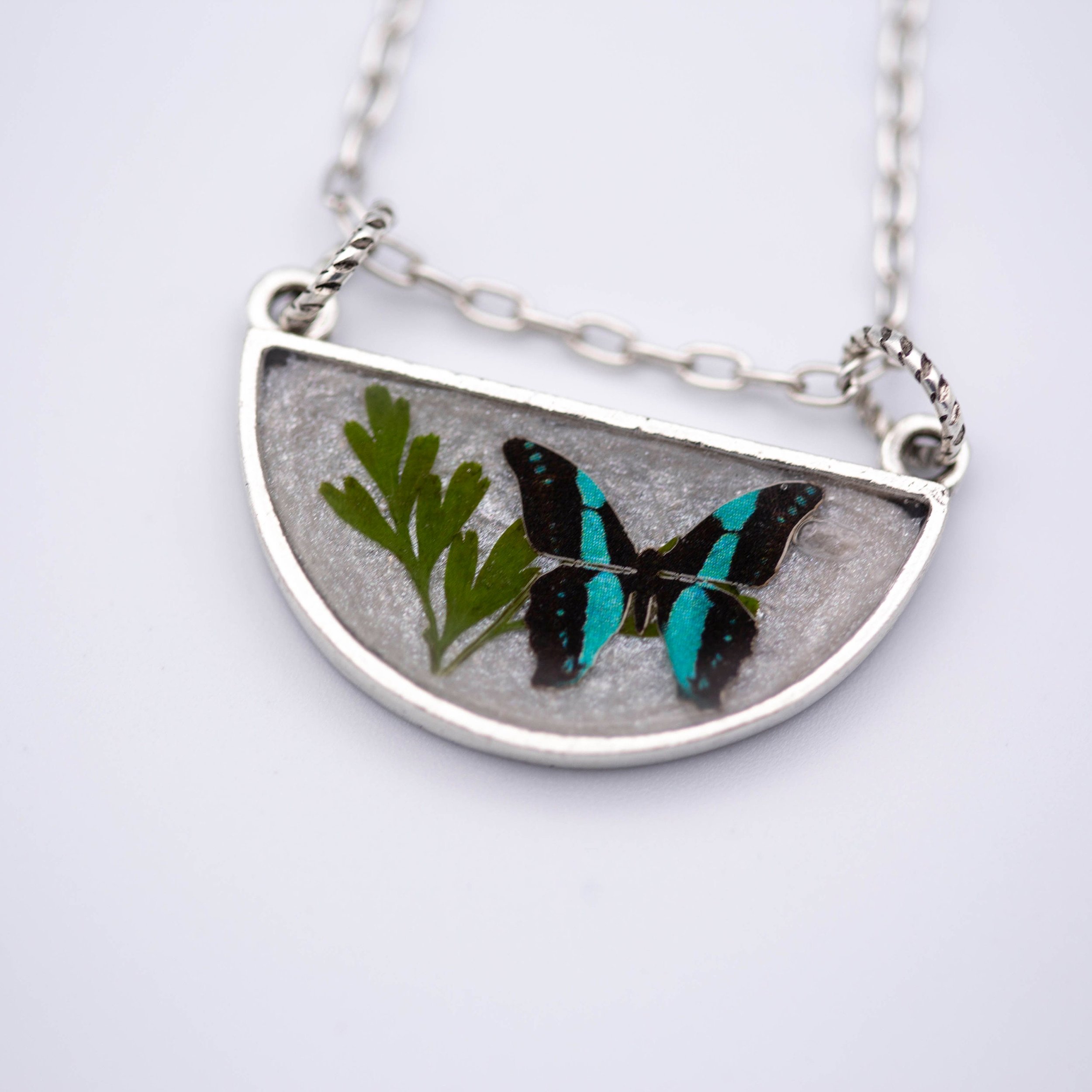 Antique silver necklace with half-circle pendant of real pressed leaf, bluebottle butterfly design, & smoky quartz gemstone in resin on a fine silver cable chain - appreciate the beauty of nature.