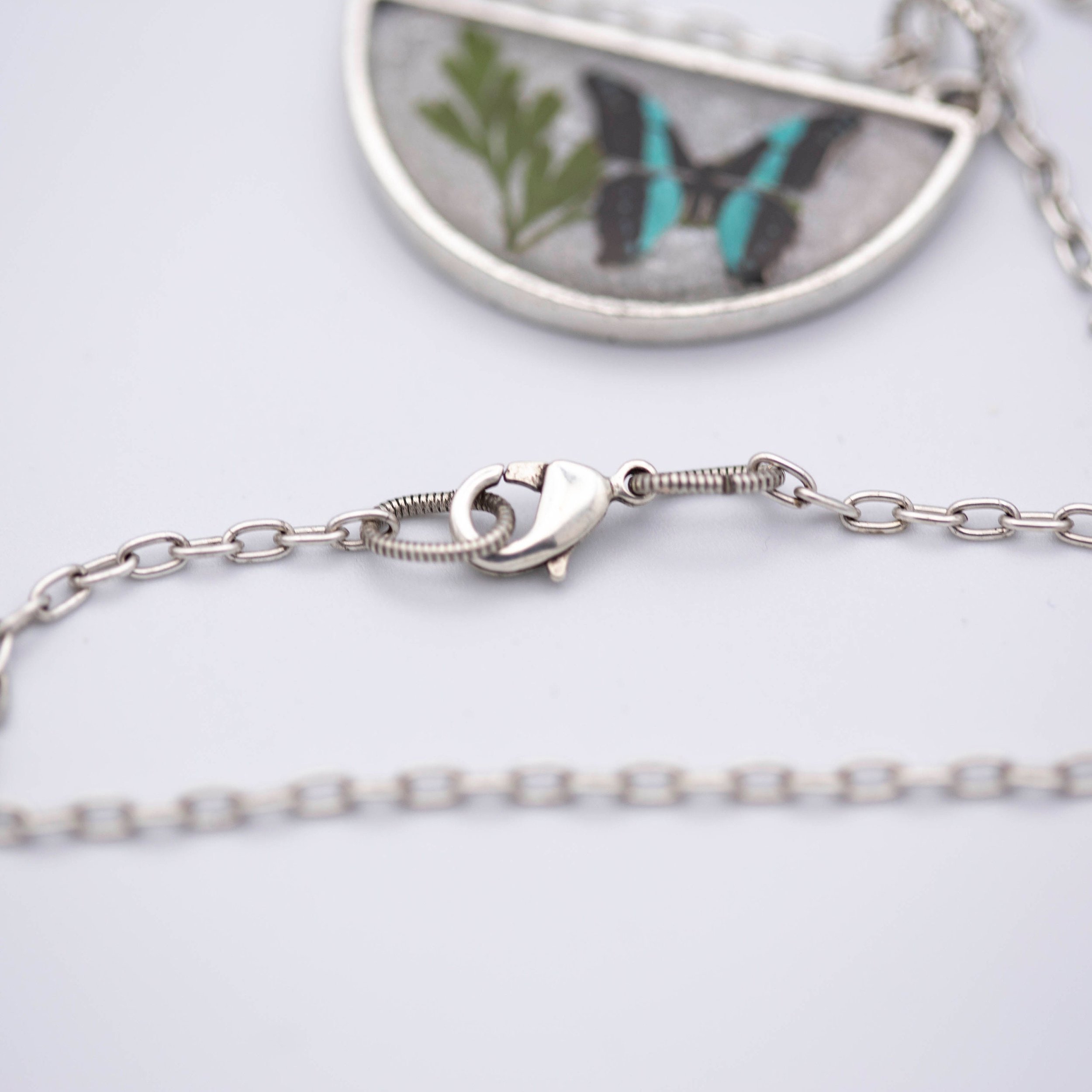 Antique silver necklace with half-circle pendant of real pressed leaf, bluebottle butterfly design, & smoky quartz gemstone in resin on a fine silver cable chain - appreciate the beauty of nature.
