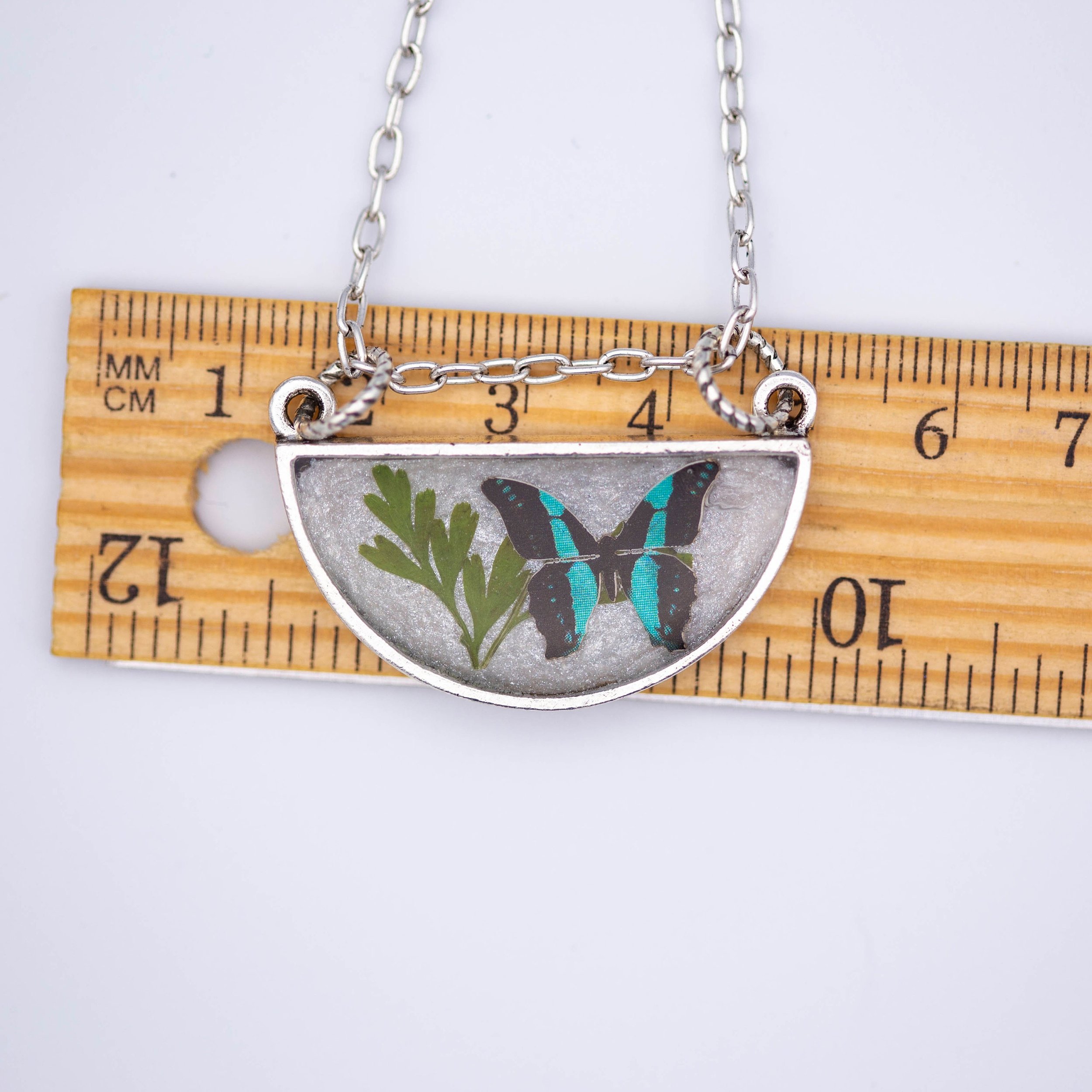 Antique silver necklace with half-circle pendant of real pressed leaf, bluebottle butterfly design, & smoky quartz gemstone in resin on a fine silver cable chain - appreciate the beauty of nature.