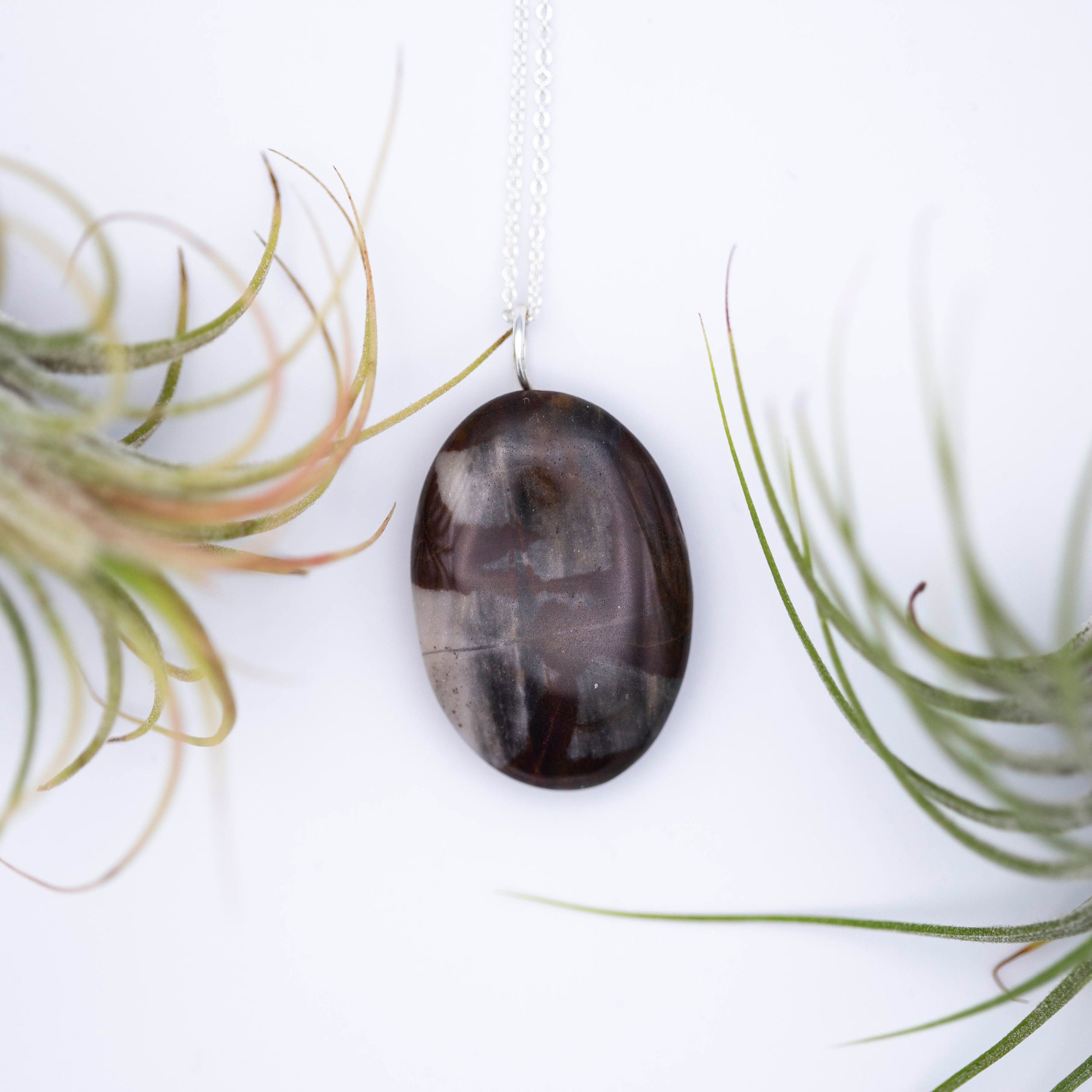 Australian outback jasper stone that has earthy brown and beige colors with black clay on the back silver gemstone necklace.