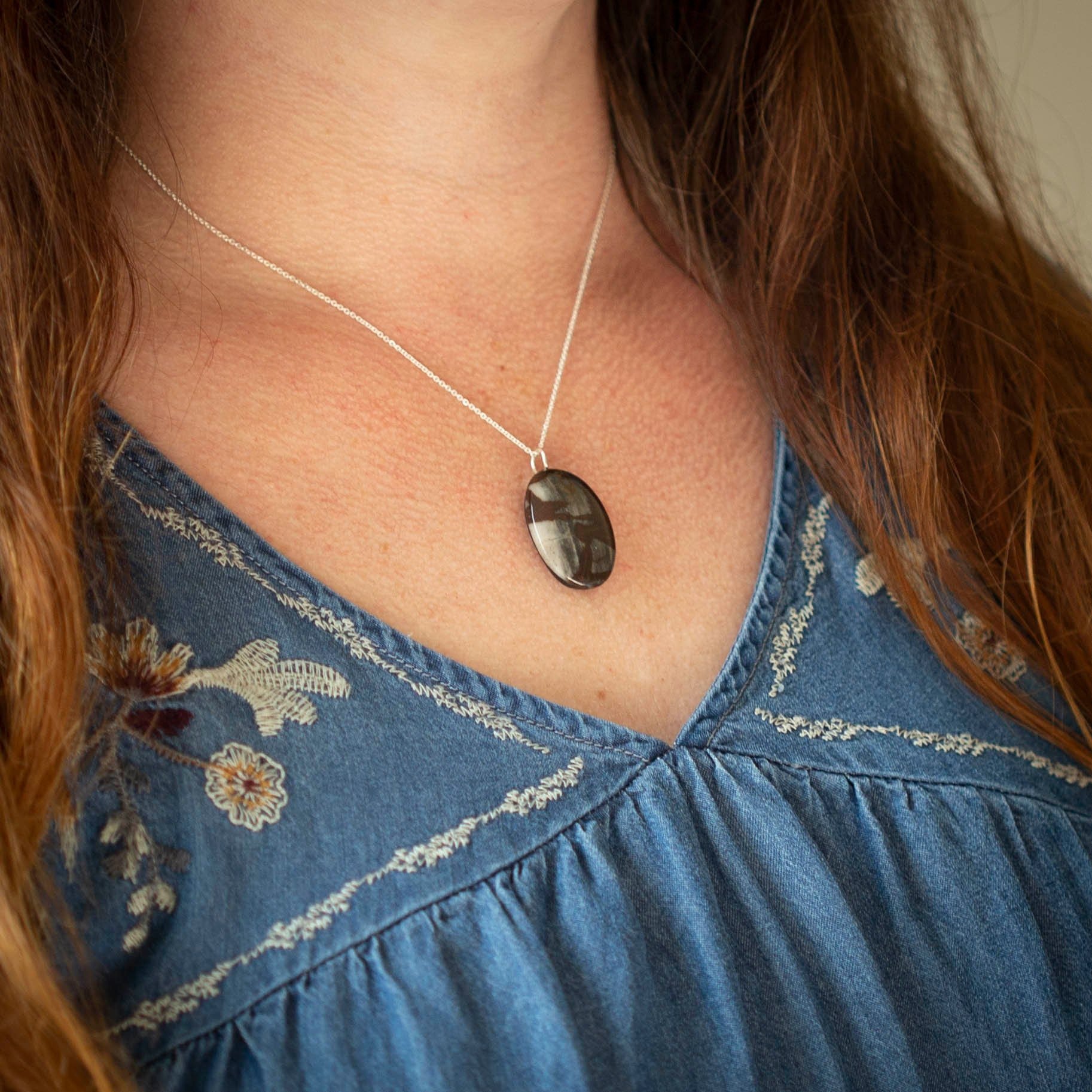 Australian outback jasper stone that has earthy brown and beige colors with black clay on the back silver gemstone necklace.
