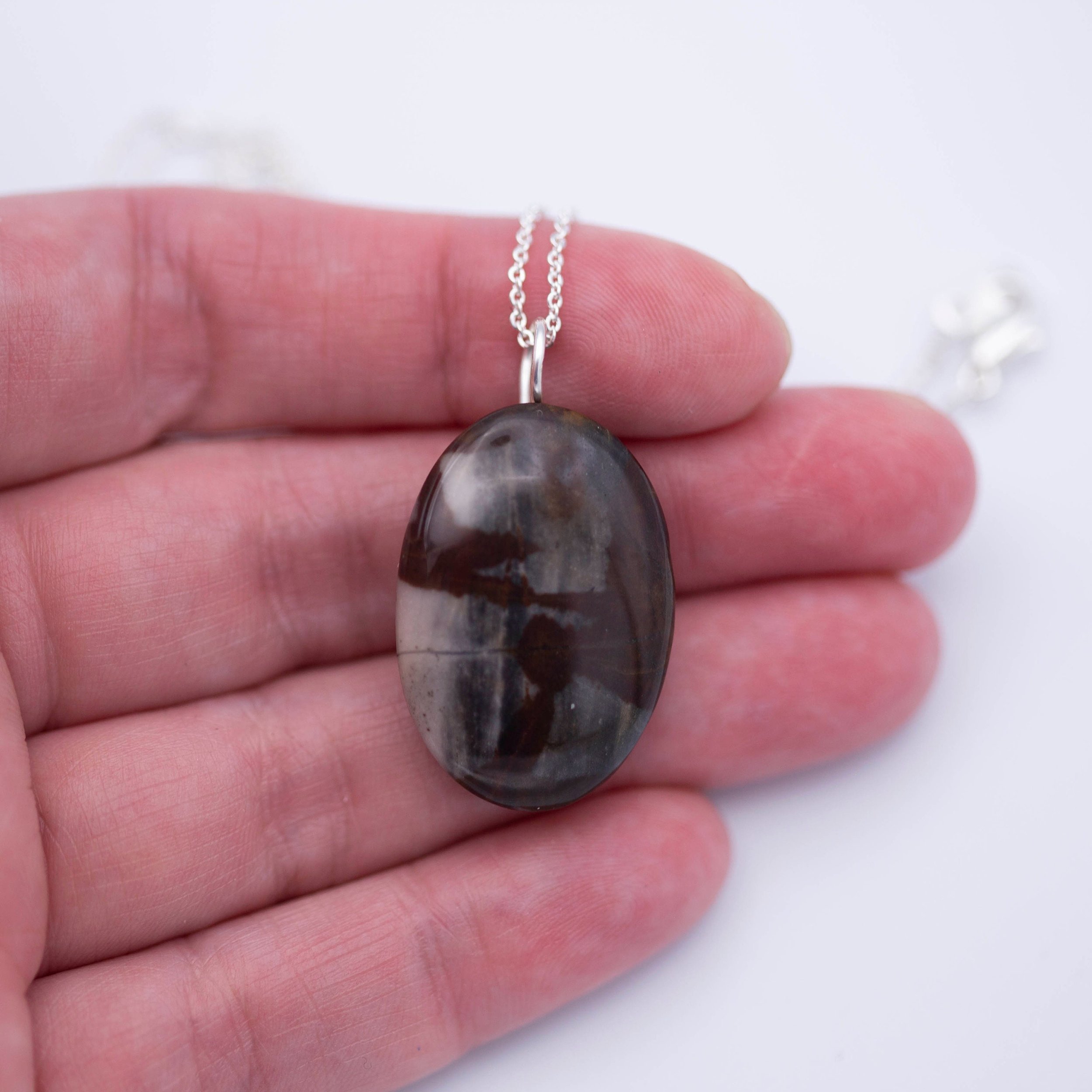 Australian outback jasper stone that has earthy brown and beige colors with black clay on the back silver gemstone necklace.
