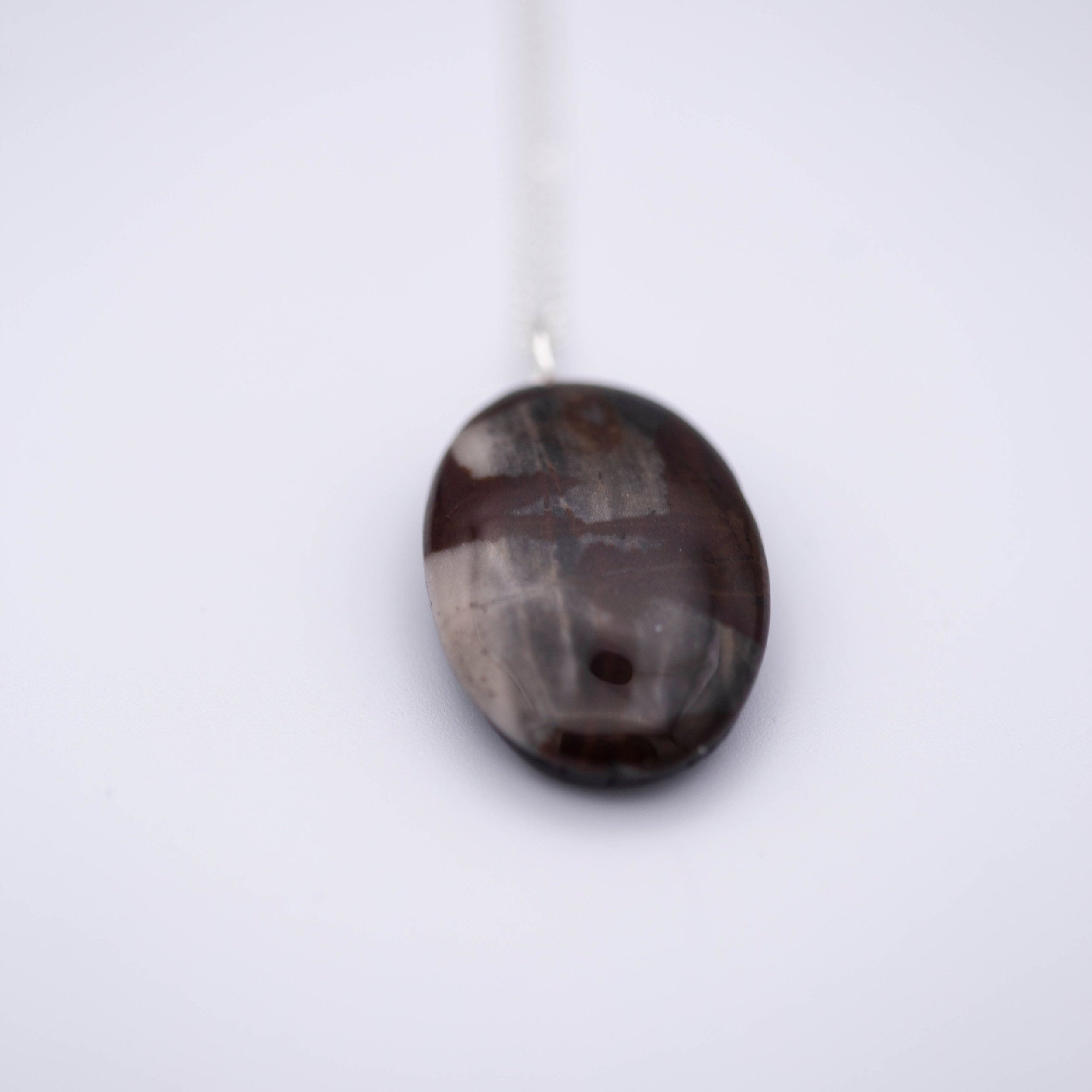 Australian outback jasper stone that has earthy brown and beige colors with black clay on the back silver gemstone necklace.