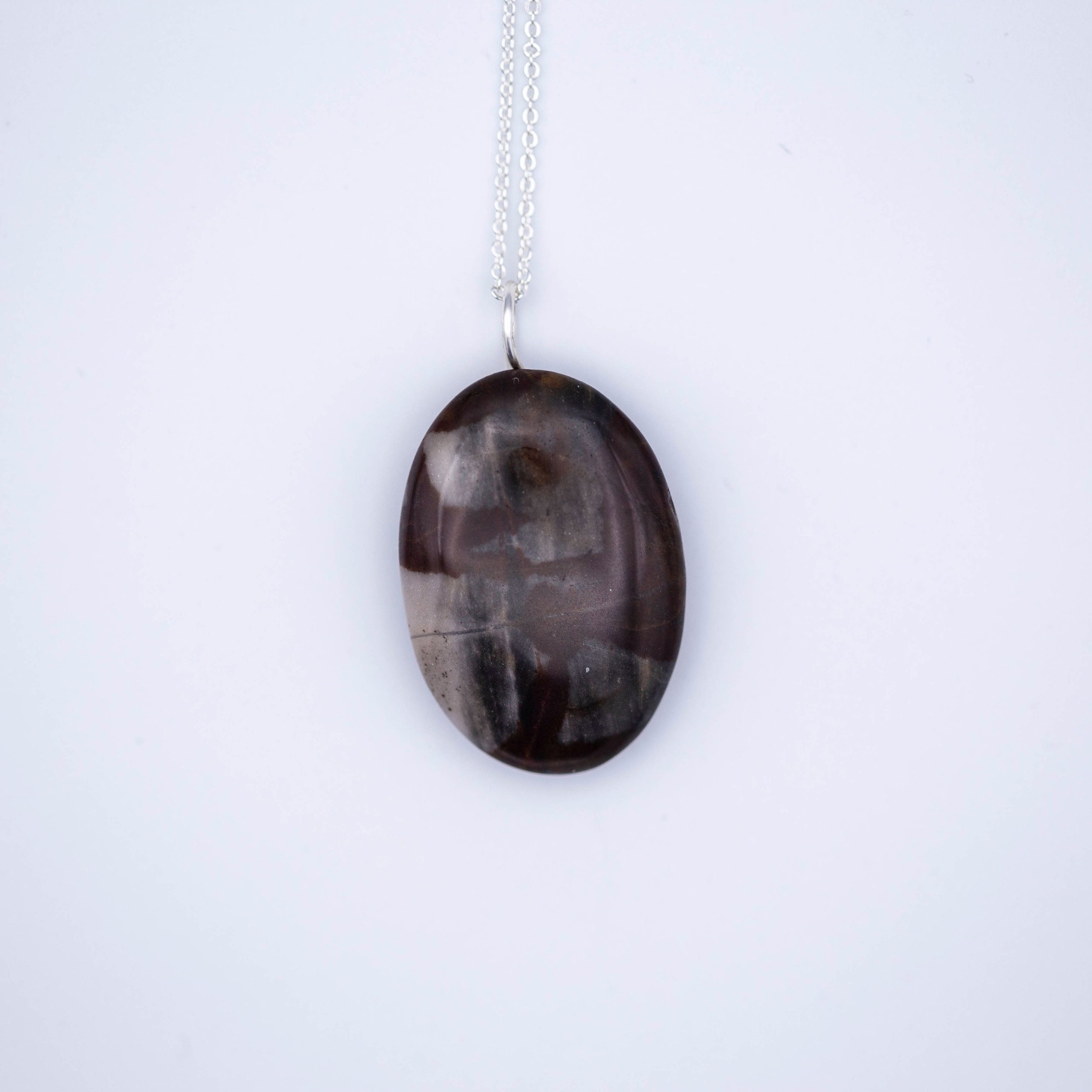 Australian outback jasper stone that has earthy brown and beige colors with black clay on the back silver gemstone necklace.