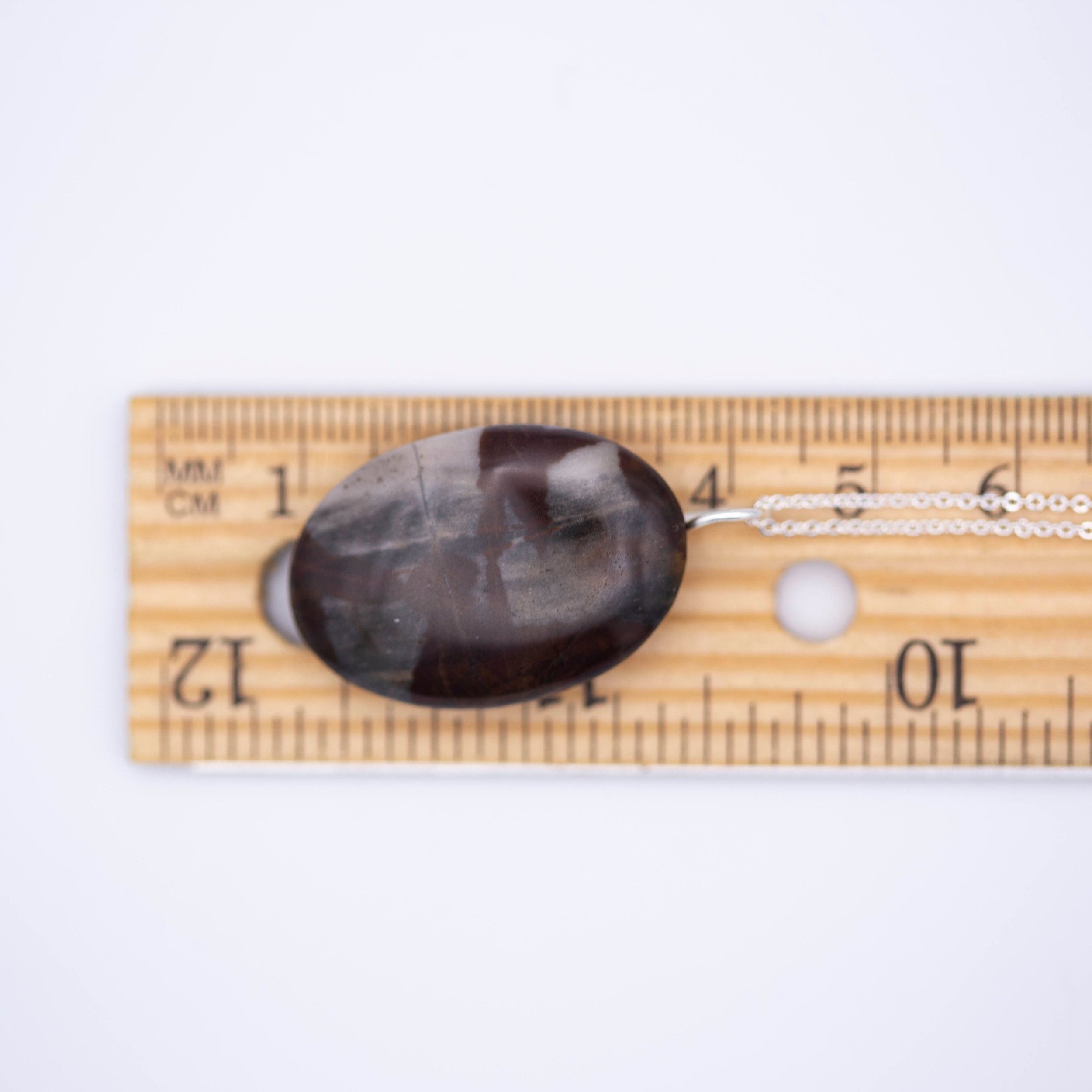 Australian outback jasper stone that has earthy brown and beige colors with black clay on the back silver gemstone necklace.