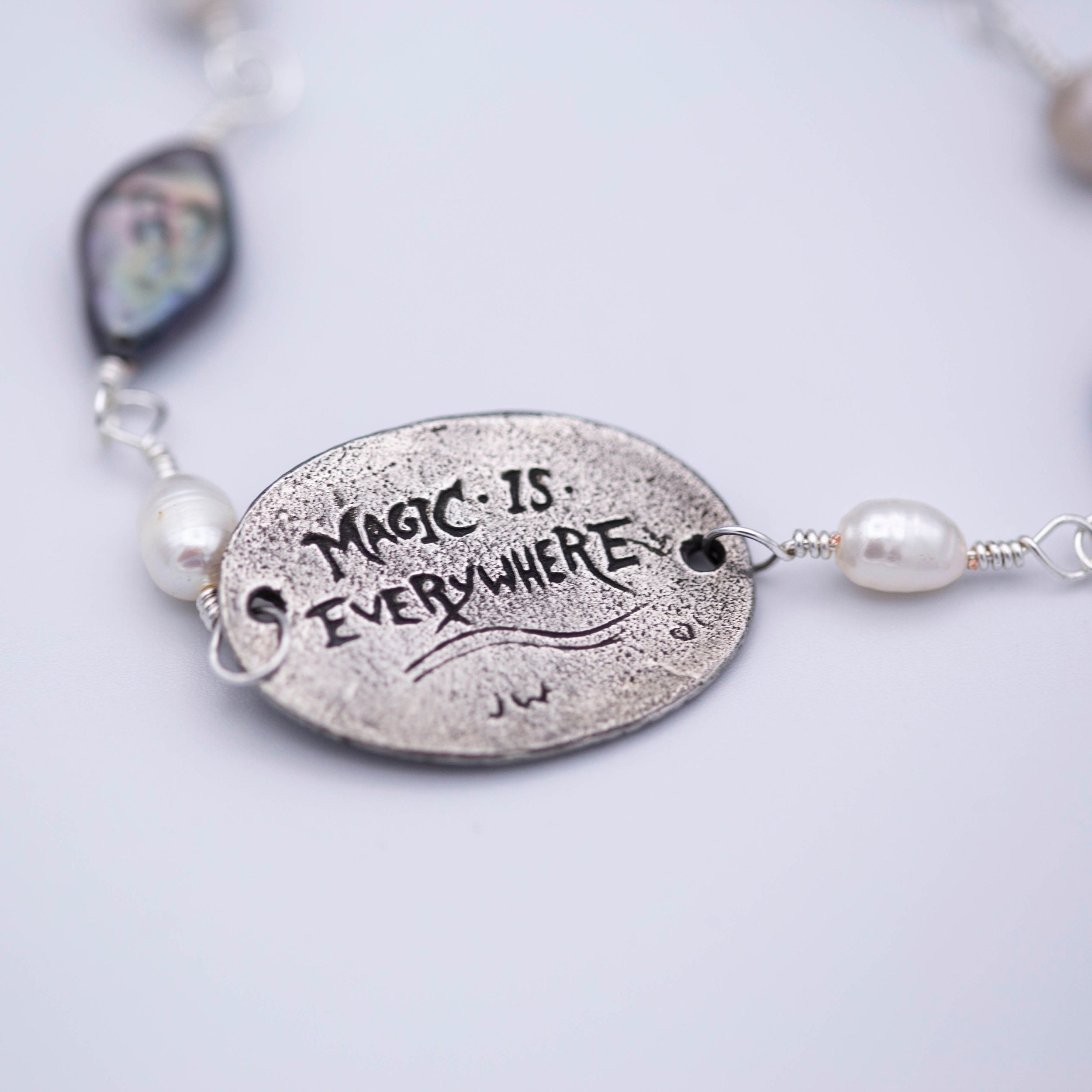 Sweet little narwhal pewter pendant with Magic is everywhere written on the back on a hand wrapped chain made of pearl and shell beads.