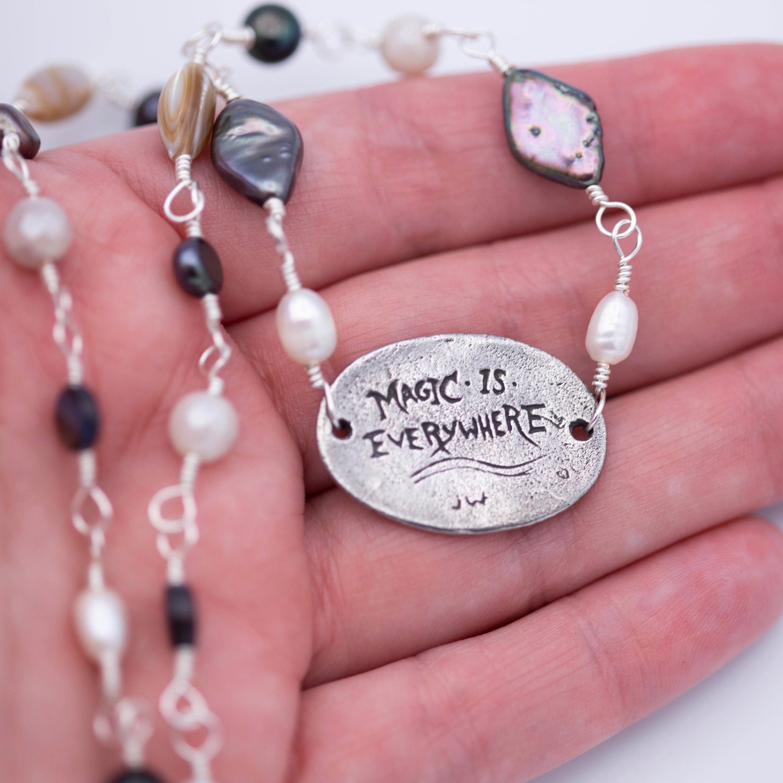 Sweet little narwhal pewter pendant with Magic is everywhere written on the back on a hand wrapped chain made of pearl and shell beads.