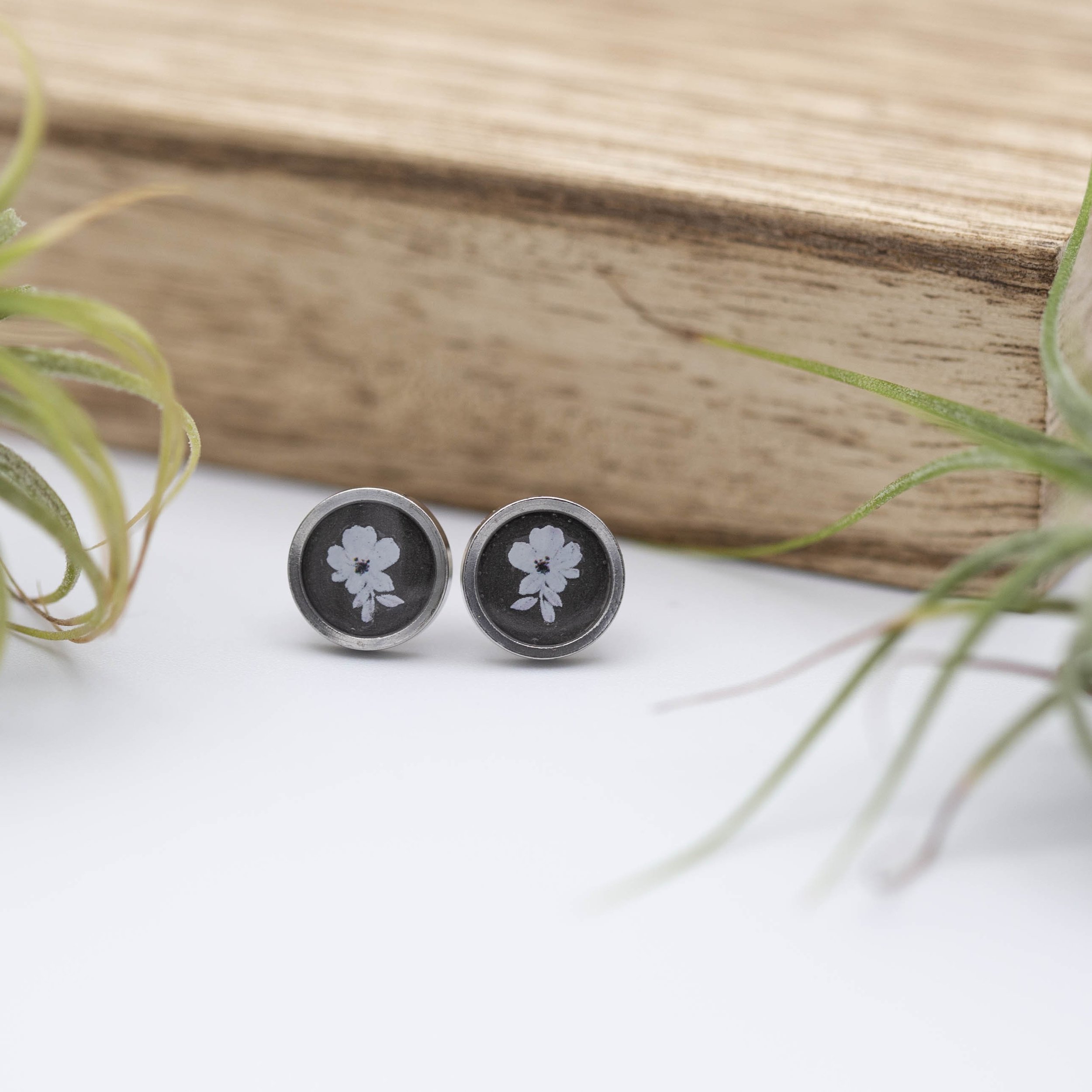 Tiny white flower design with white bronze metallic background stainless steel earrings.