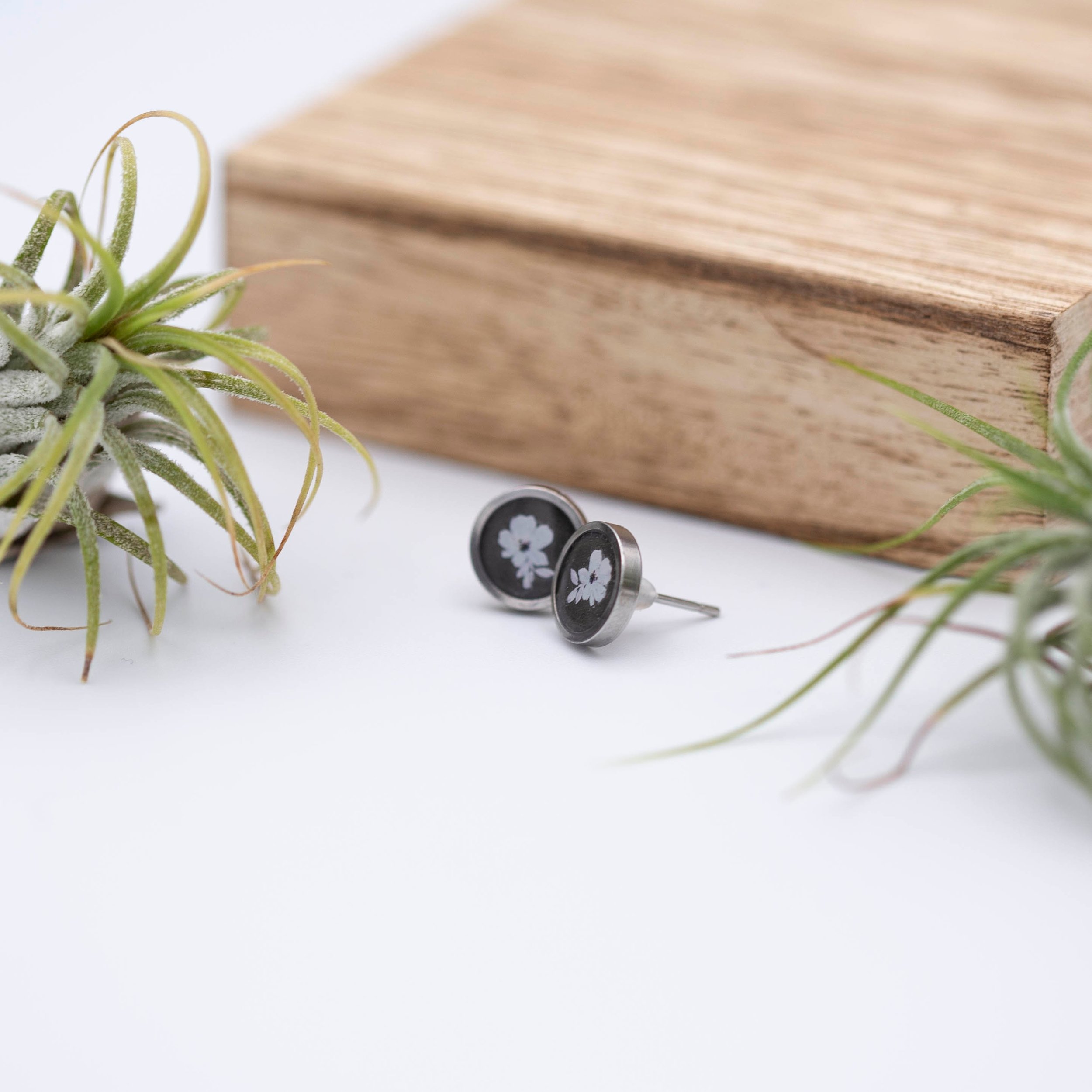 Tiny white flower design with white bronze metallic background stainless steel earrings.