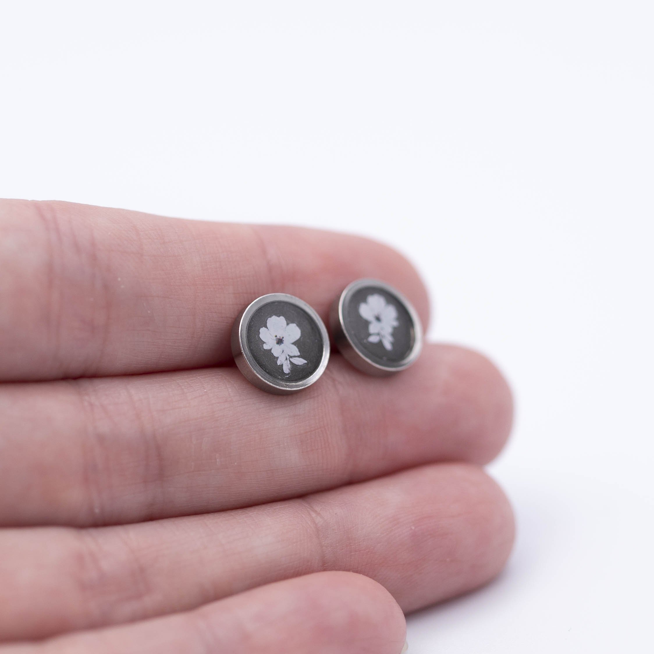 Tiny white flower design with white bronze metallic background stainless steel earrings.