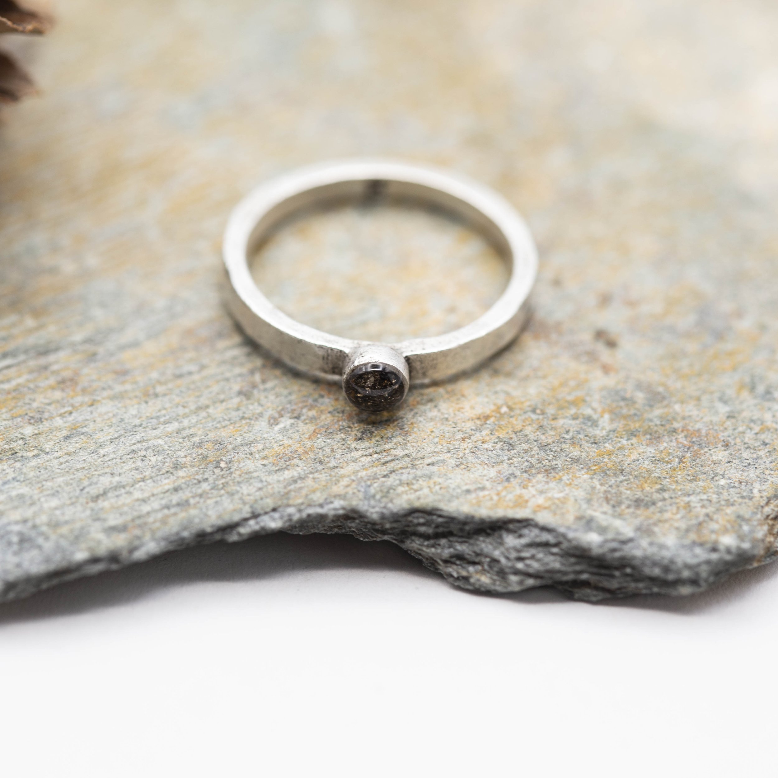 A fine silver plated pewter stacking ring with a bold circle setting of Canyon Diablo Meteorite in resin, bringing the stars closer to you.