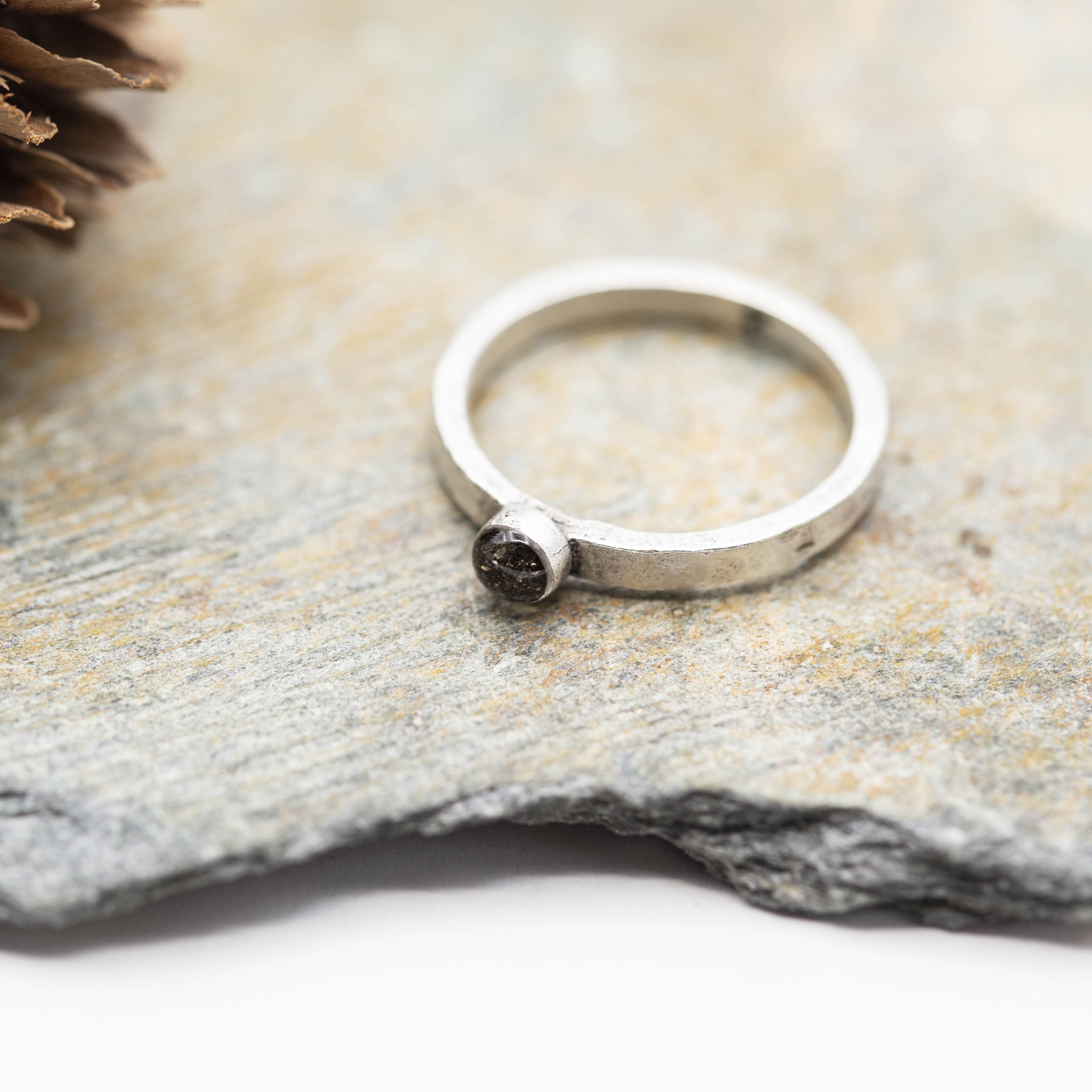 A fine silver plated pewter stacking ring with a bold circle setting of Canyon Diablo Meteorite in resin, bringing the stars closer to you.