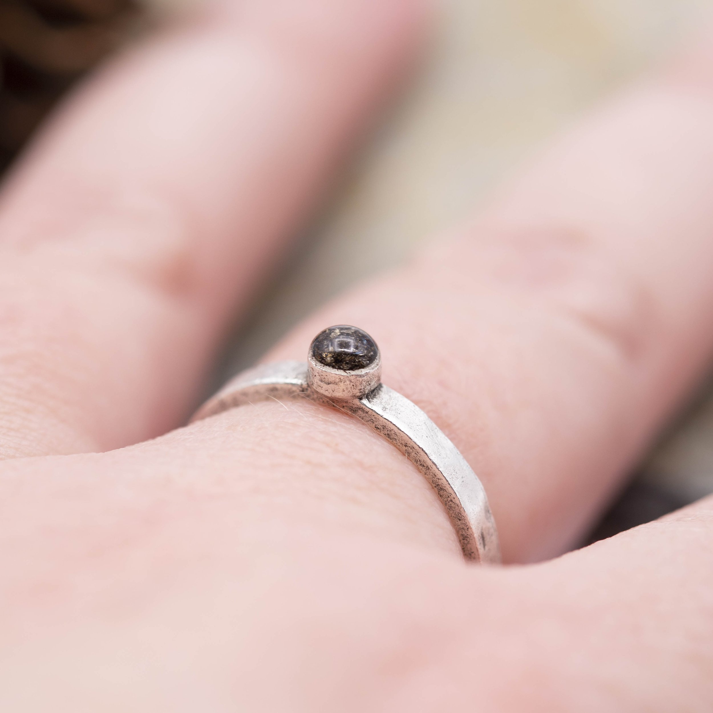 A fine silver plated pewter stacking ring with a bold circle setting of Canyon Diablo Meteorite in resin, bringing the stars closer to you.