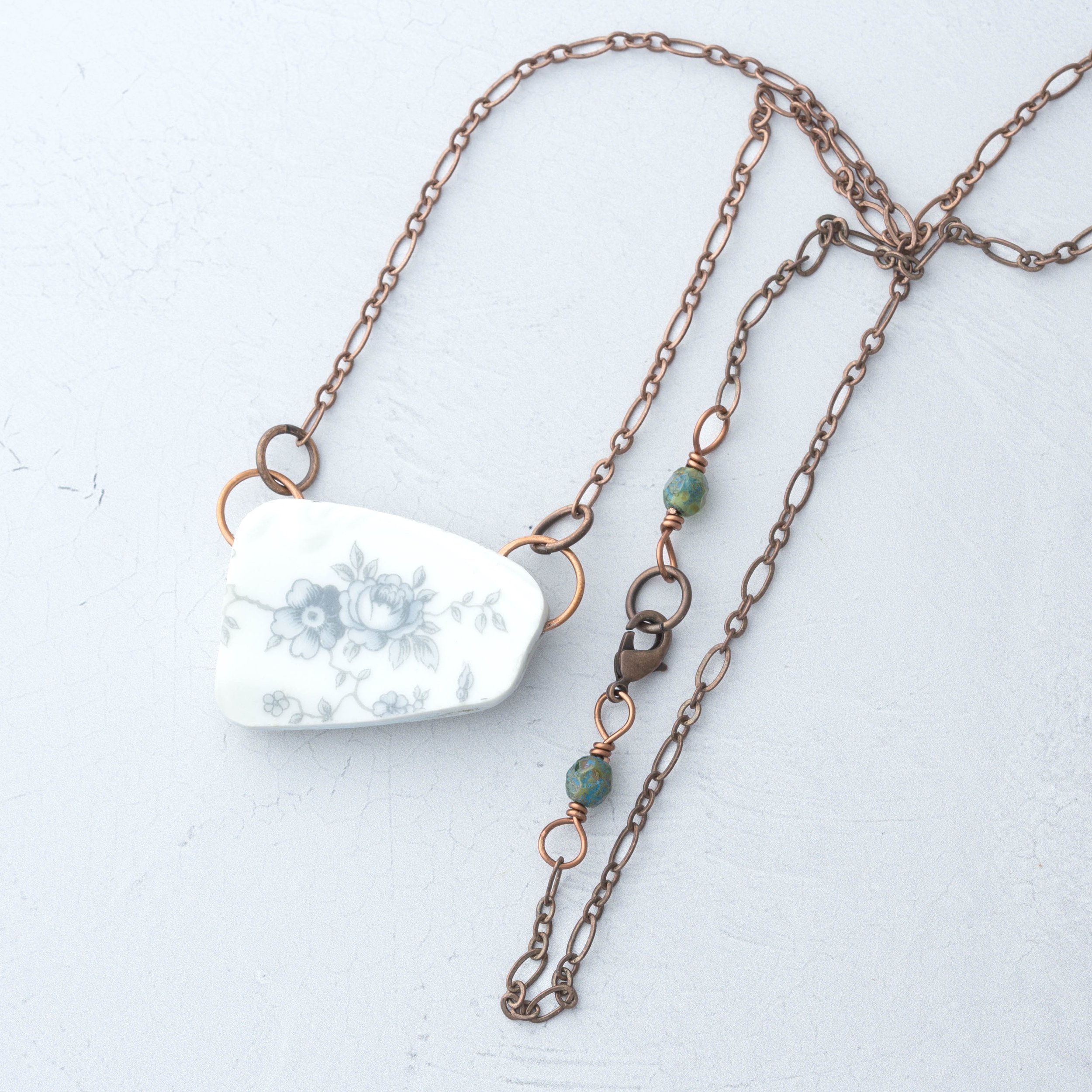 Nature inspired broken china necklace with delicate blue flowers and a whimsical mushroom design. Includes rustic copper chain and two blue Czech glass beads for an earthy, beautiful look.