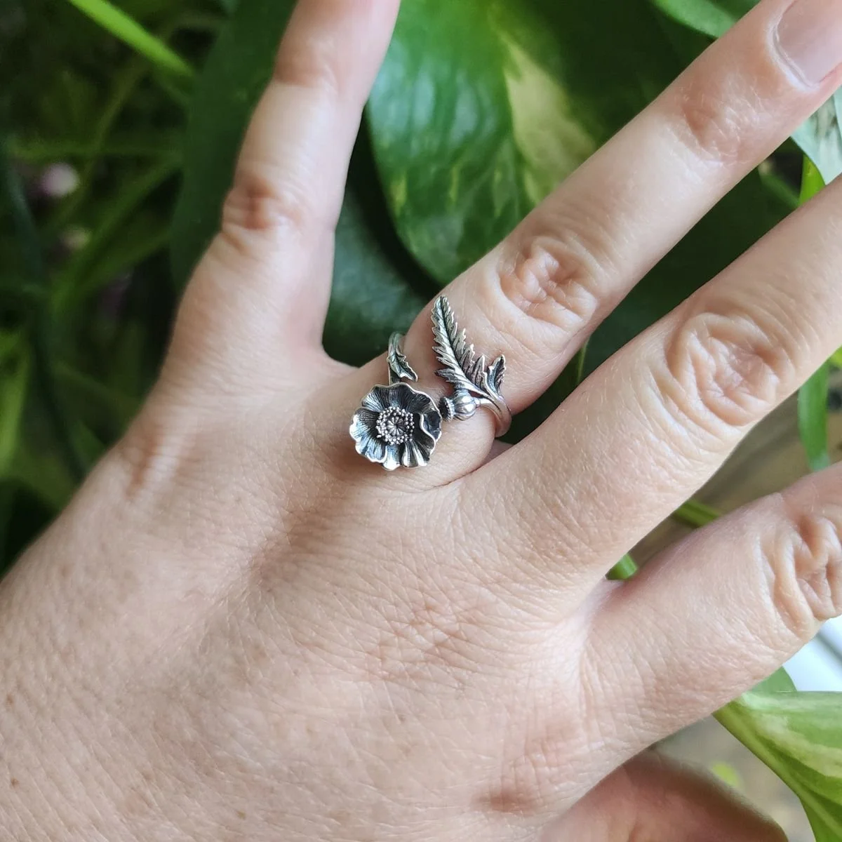 Sterling silver adjustable ring featuring a blooming poppy flower, symbolizing remembrance, healing, and the August birth flower.