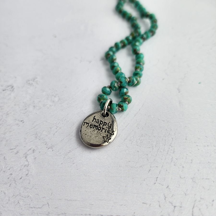 hand knotted green czech glass bead necklace with pewter elephant charm and happy memories engraved on the back handmade jewelry with lobster clasp