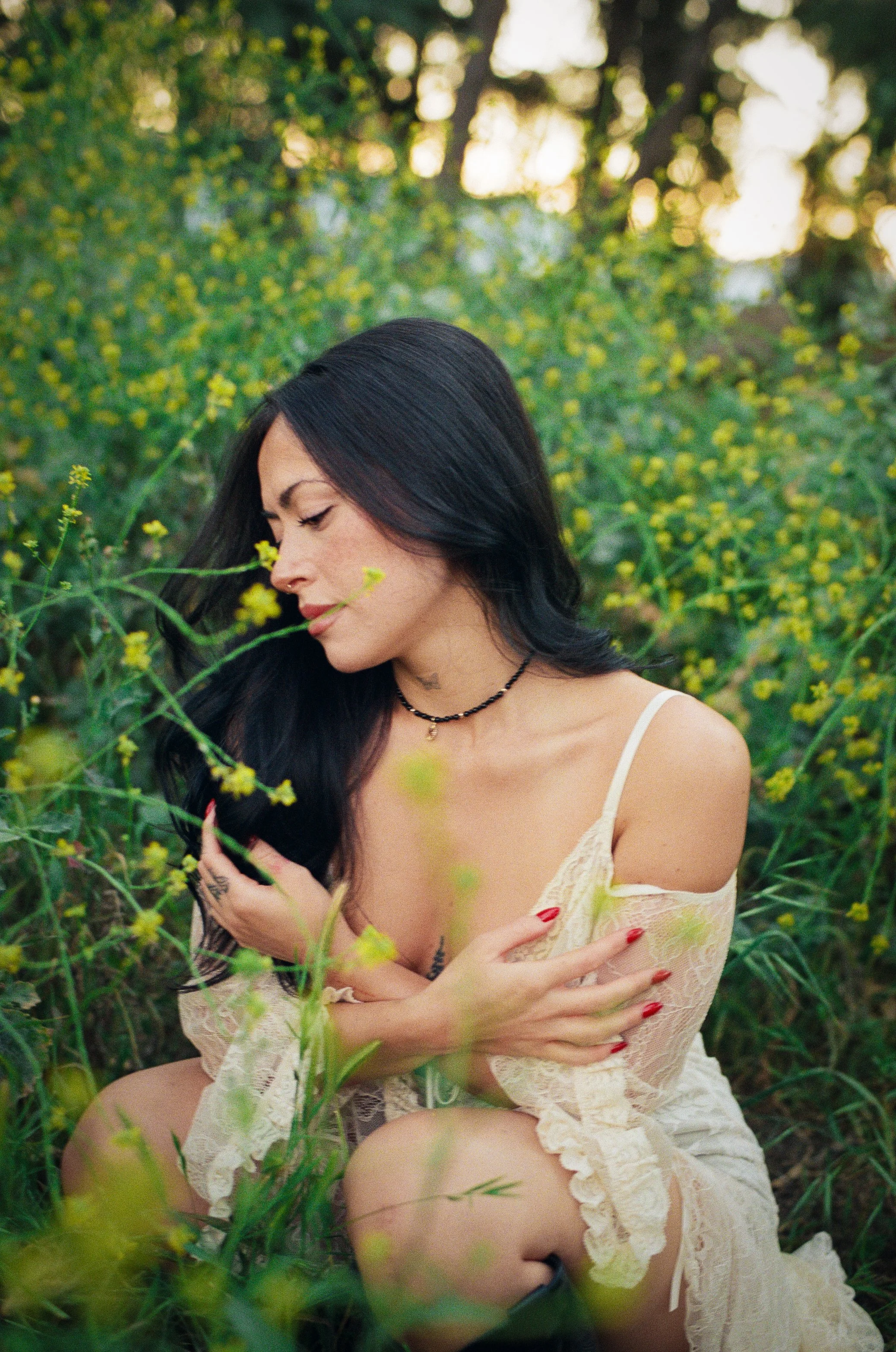 girl in nature wearing white dress and black boots bathed in sunlight