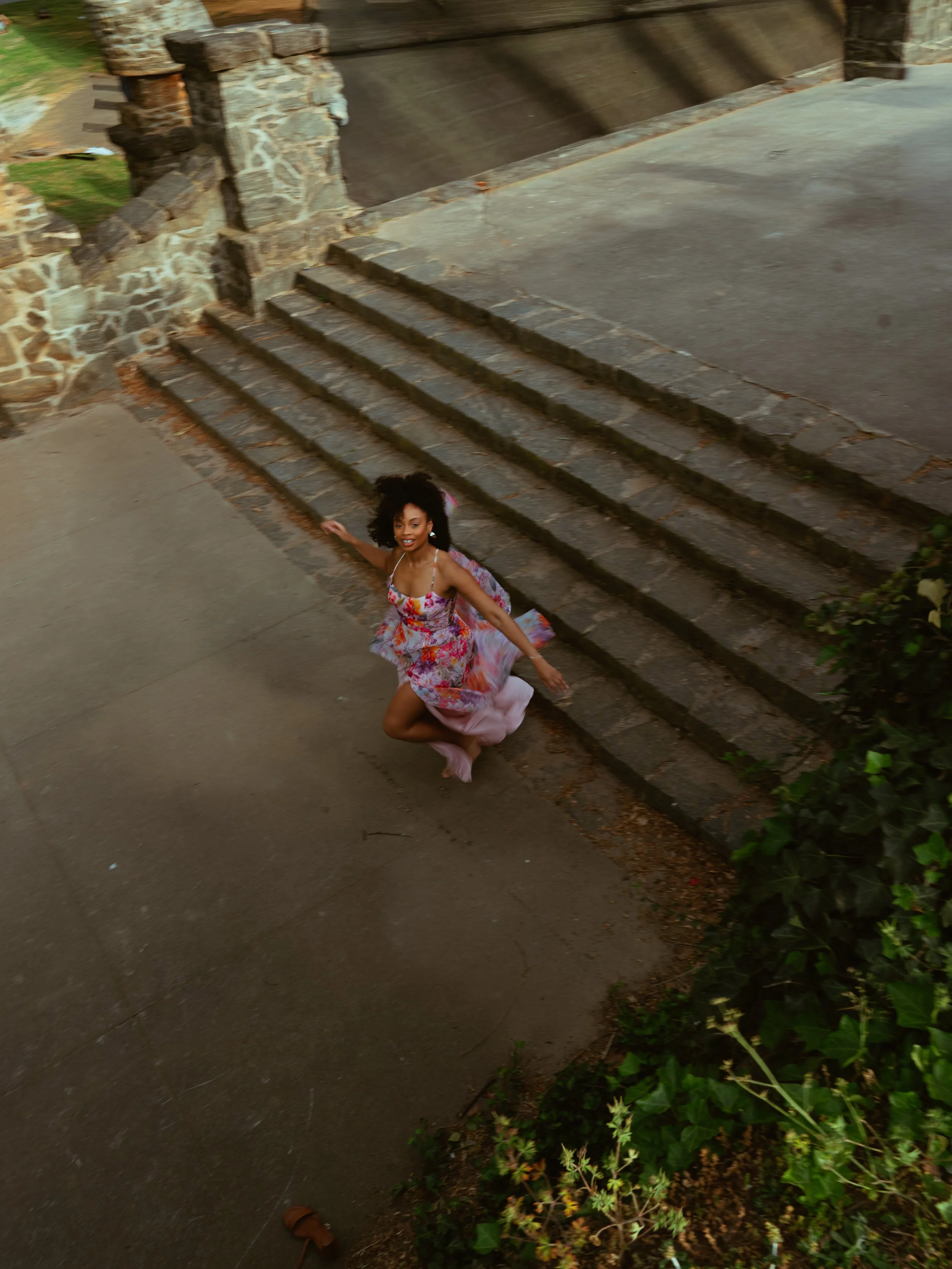 Women jumps off of stone steps happily