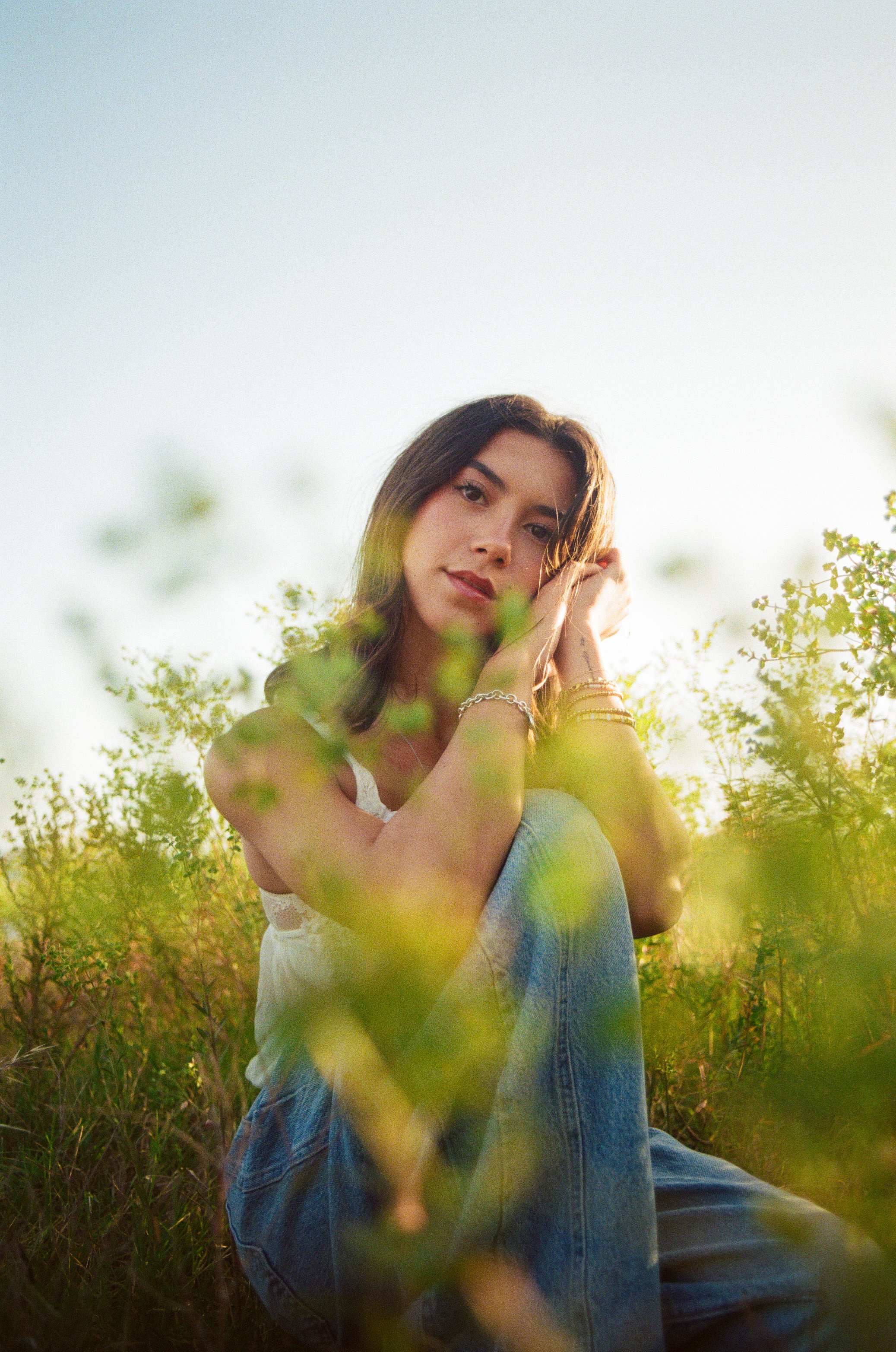 girl sits in grass casually