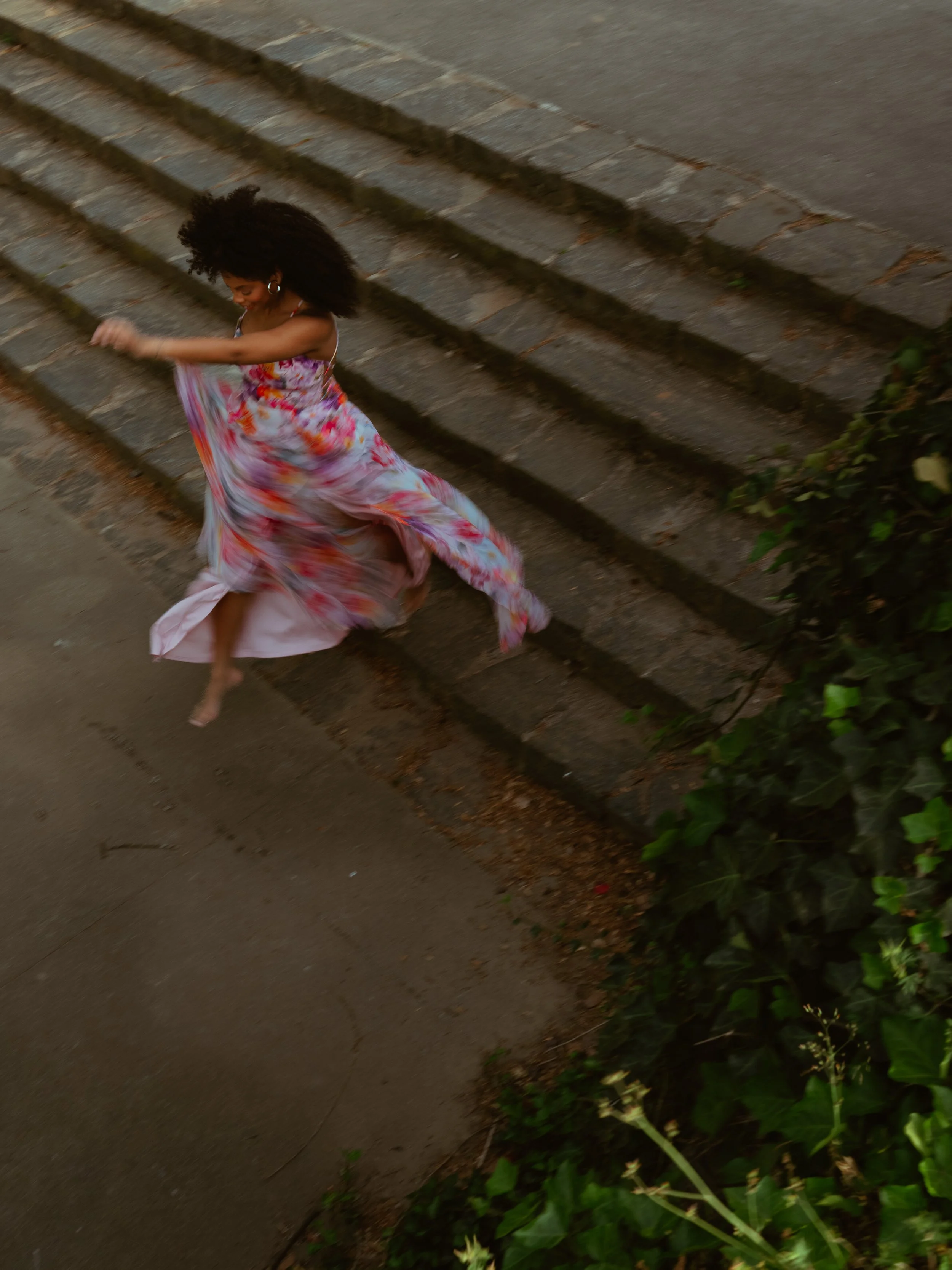 Women jumps off of stone steps happily