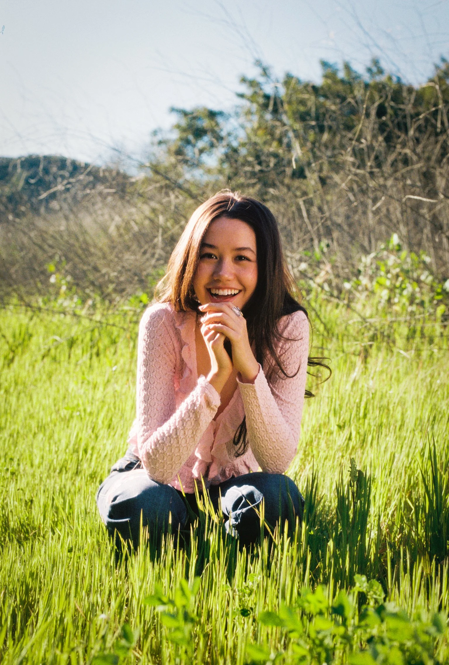 Young woman smiling in a field of grass