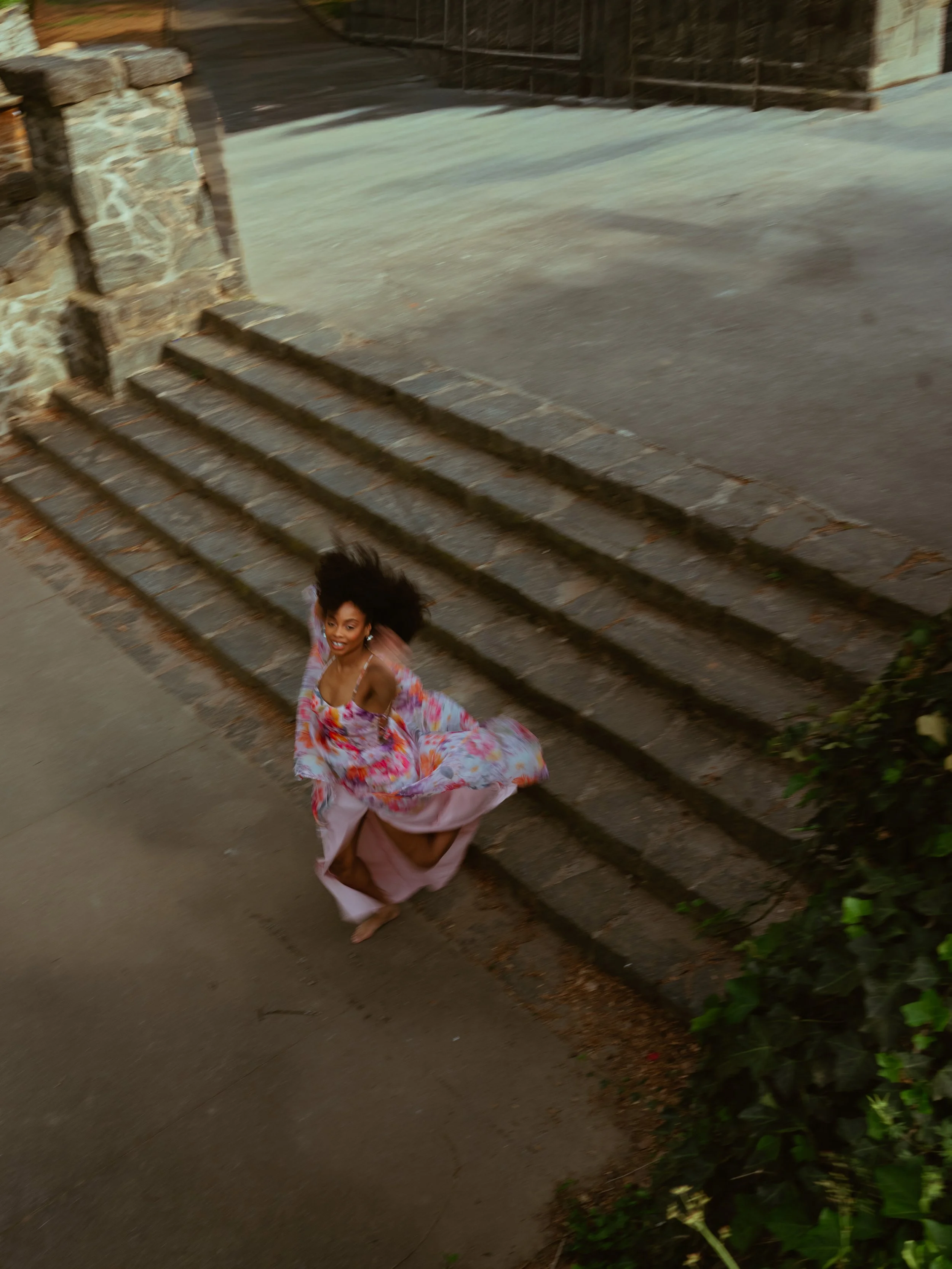 Women jumps off of stone steps happily