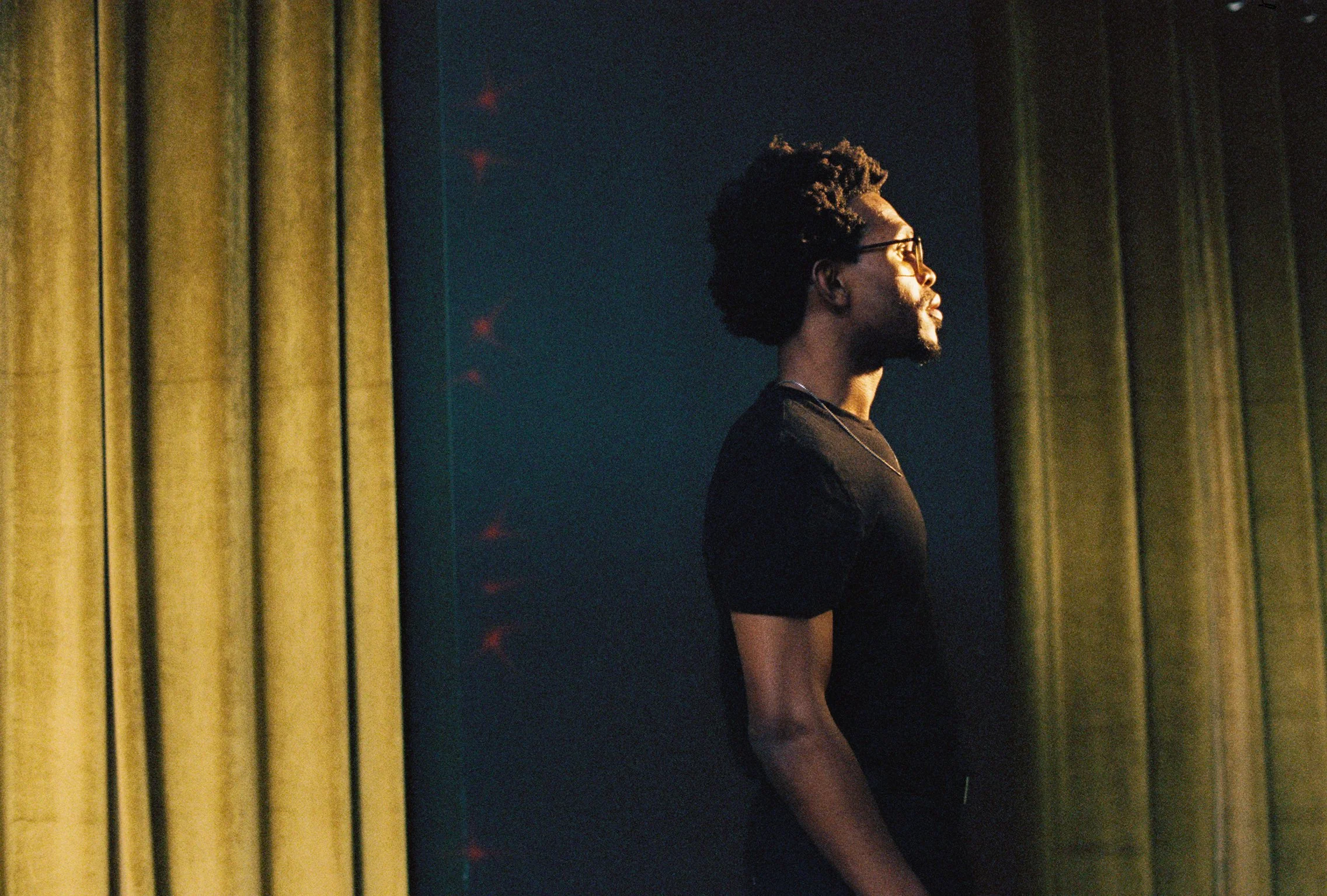 Camrus Johnson in front of yellow curtain