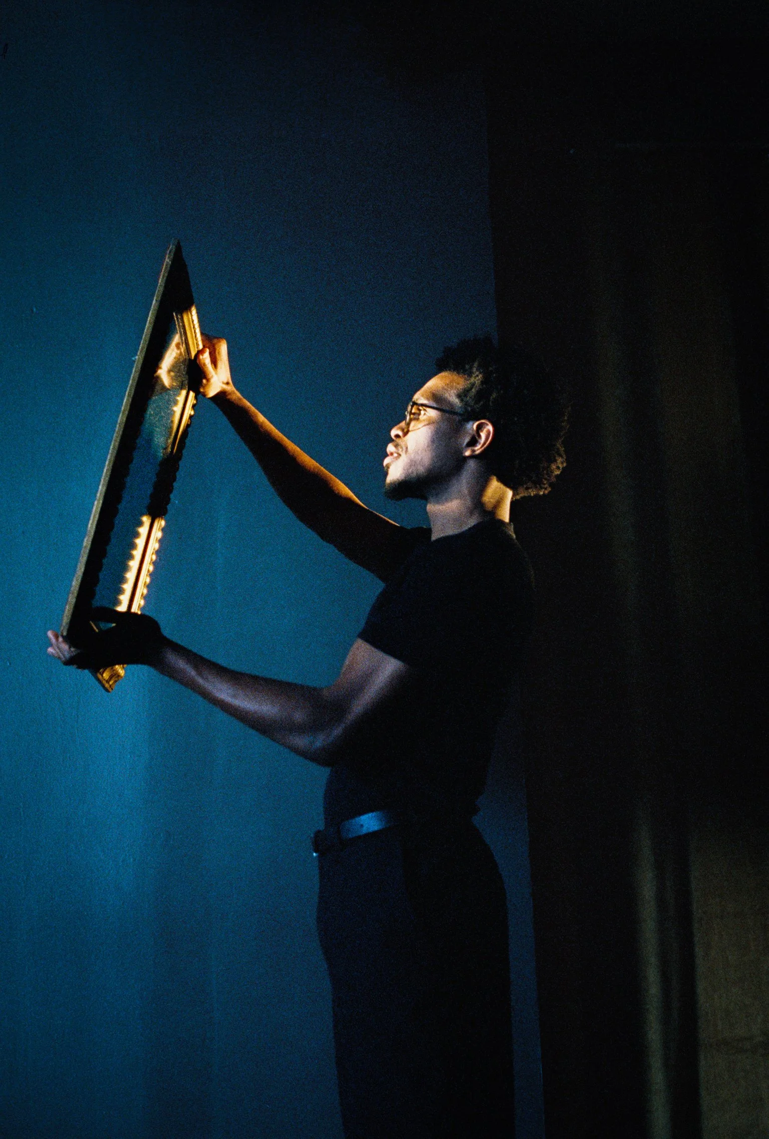 Camrus Johnson holding a mirror