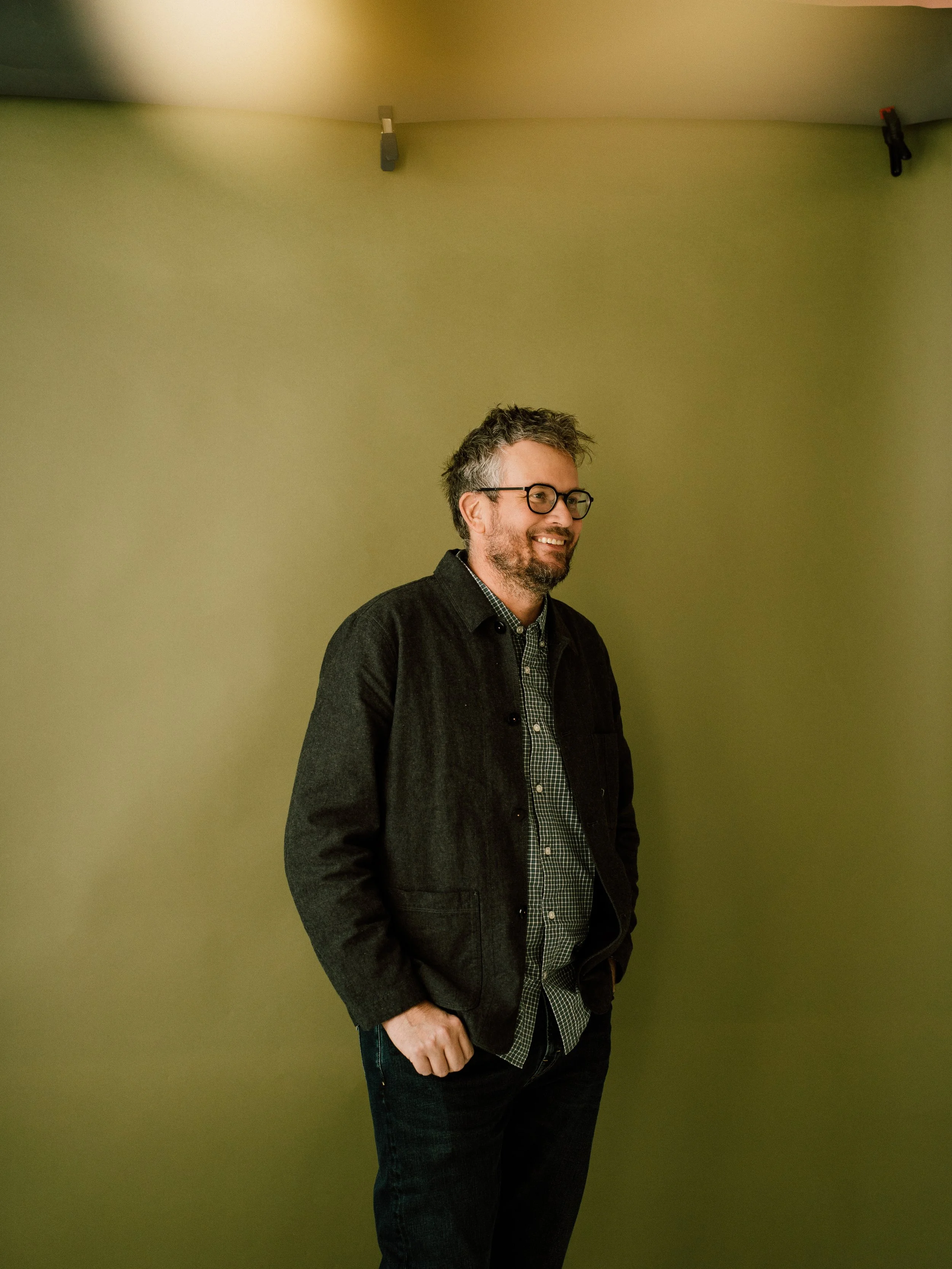 Man (John Green) in front of green backdrop