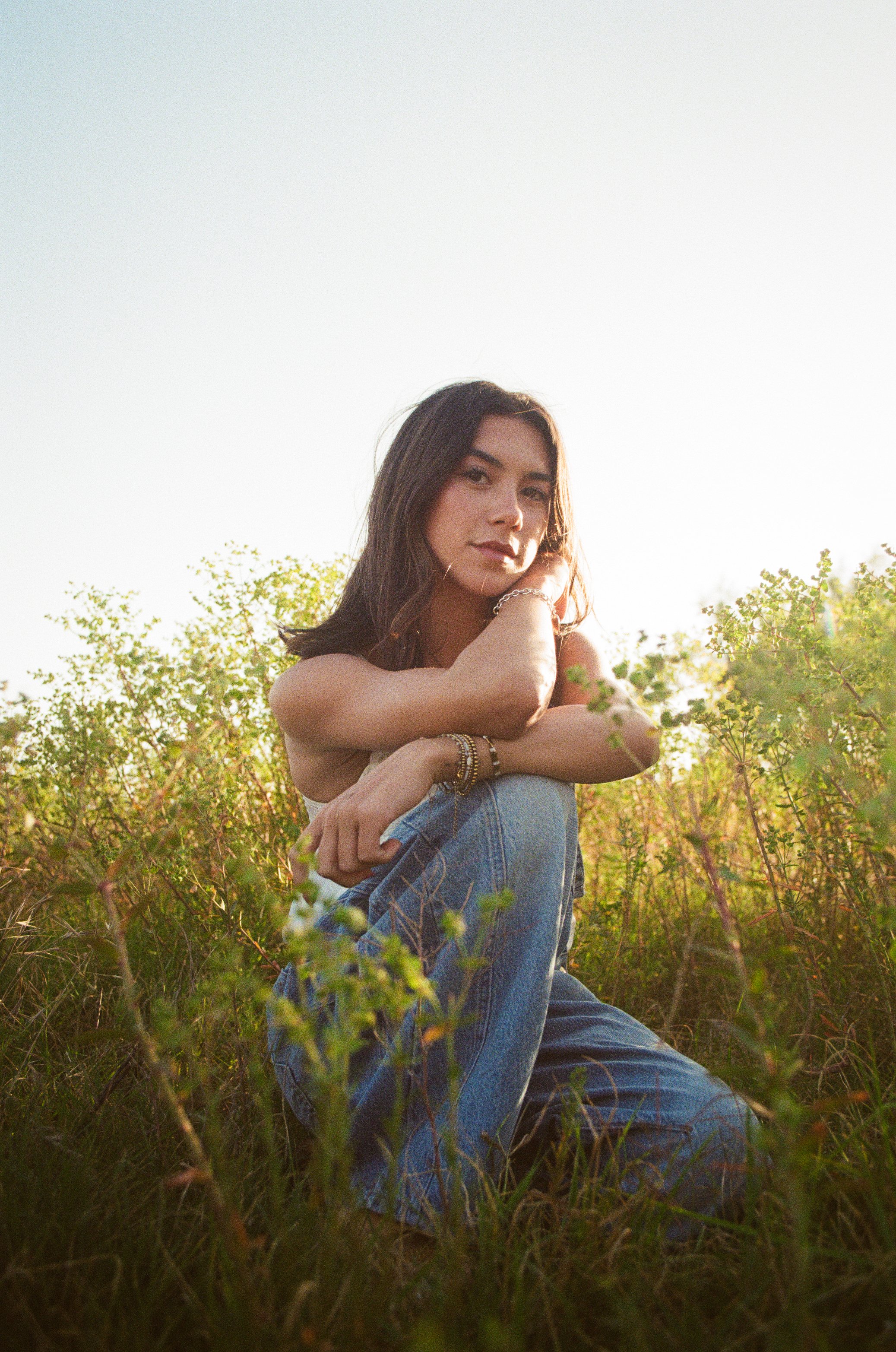 girl sits in grass casually