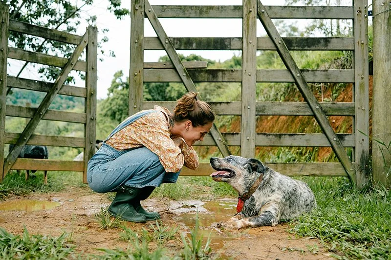 A woman talking to a dog at the farm gate for the Pawsome Interactions farm event