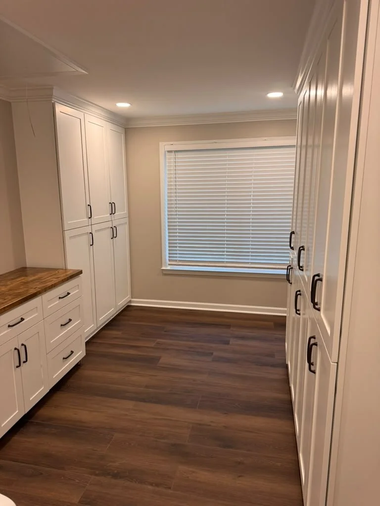 Spacious remodeled laundry room with built-in cabinetry on both walls