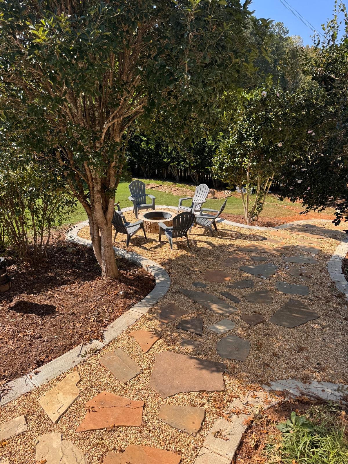 Backyard fire pit patio with pea gravel and flagstone stepping stone pathway in East Cobb, GA