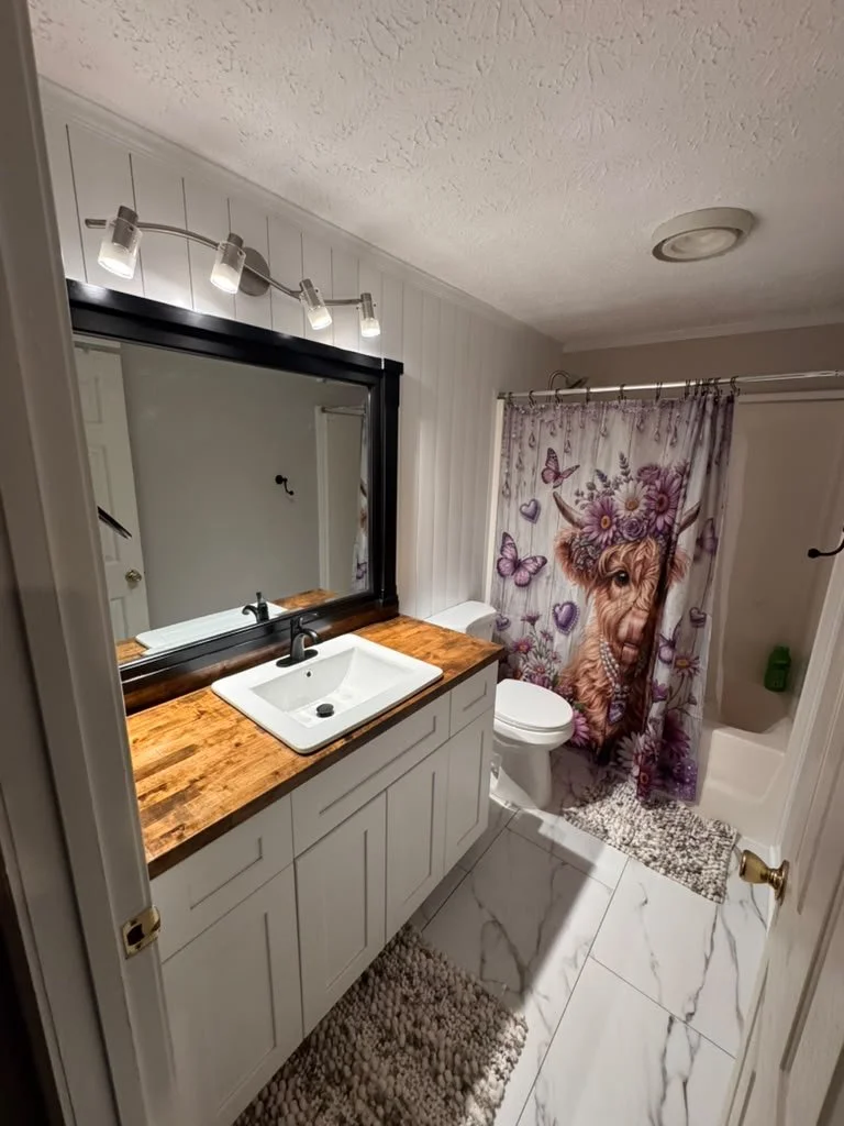 Completed bathroom remodel in East Cobb with butcher block vanity, shiplap wall and porcelain tile floor