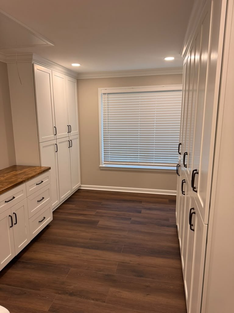 Spacious remodeled laundry room with built-in cabinetry on both walls by A&J Remodeling