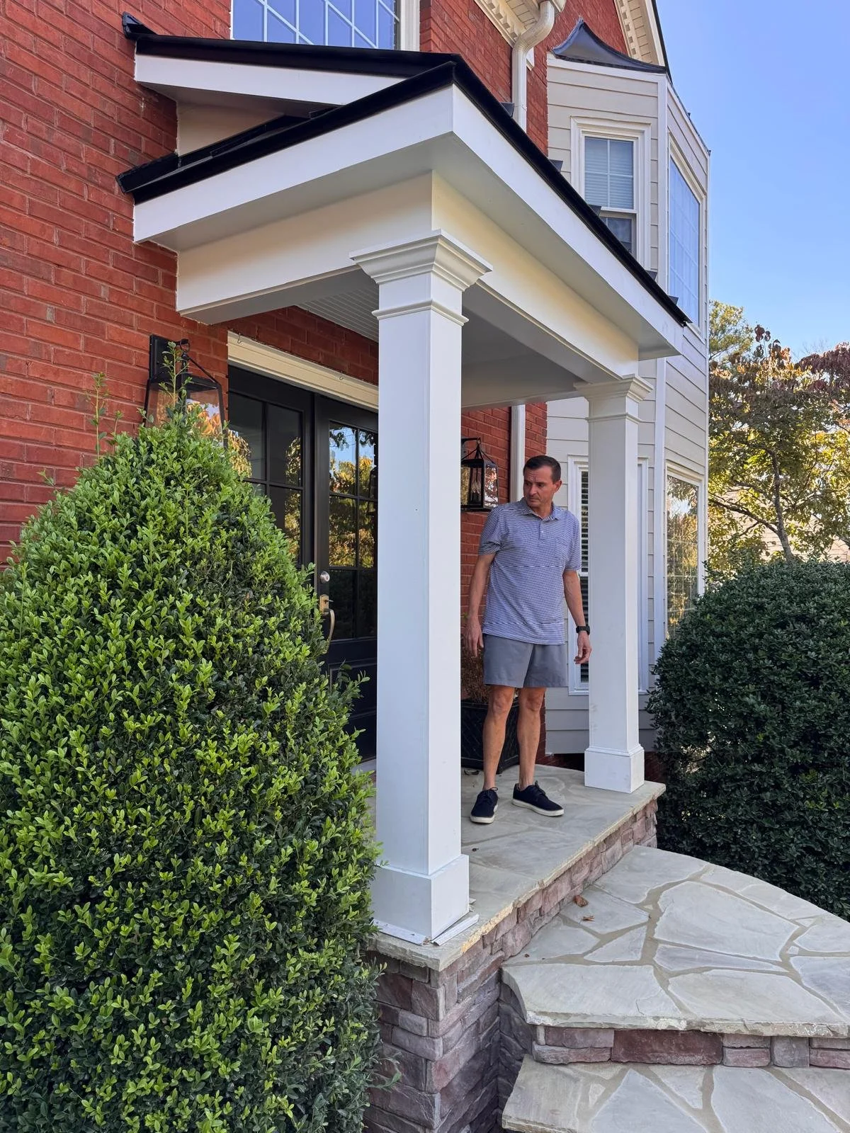 Front porch portico with white square columns and flagstone floor in East Cobb, GA