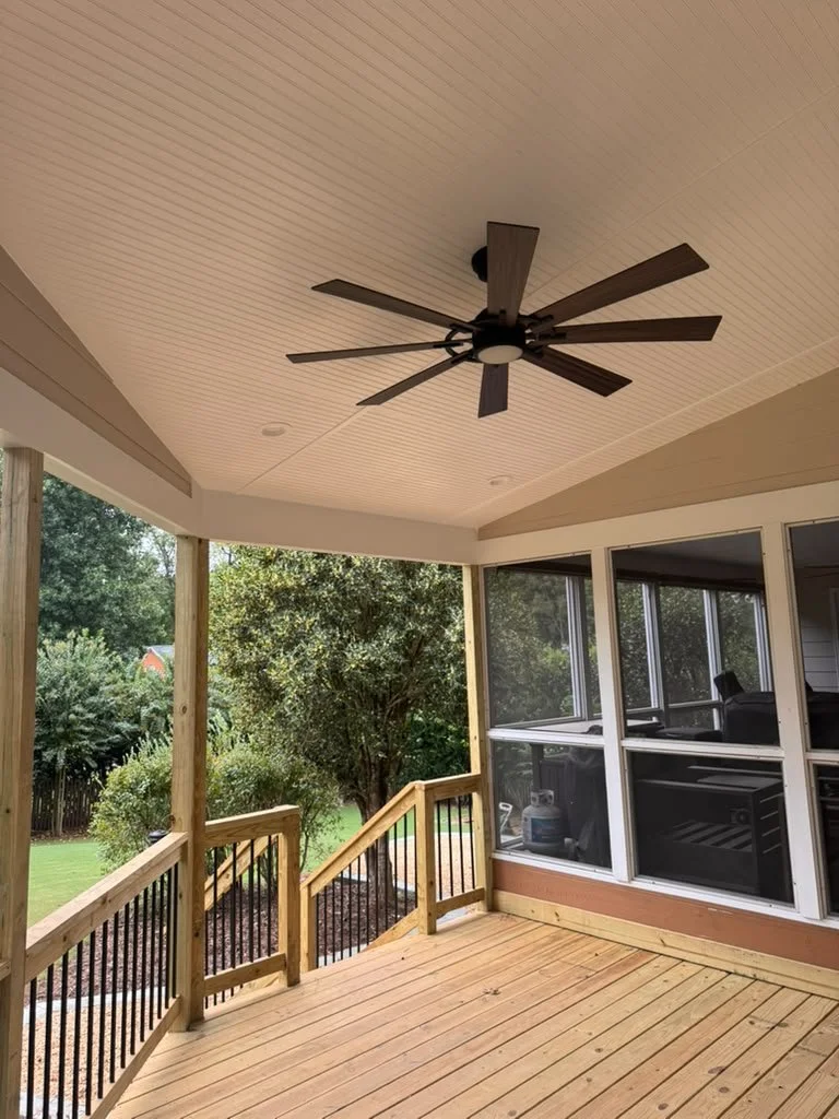 Covered porch with vaulted beadboard ceiling, ceiling fan and pressure-treated deck railings in East Cobb