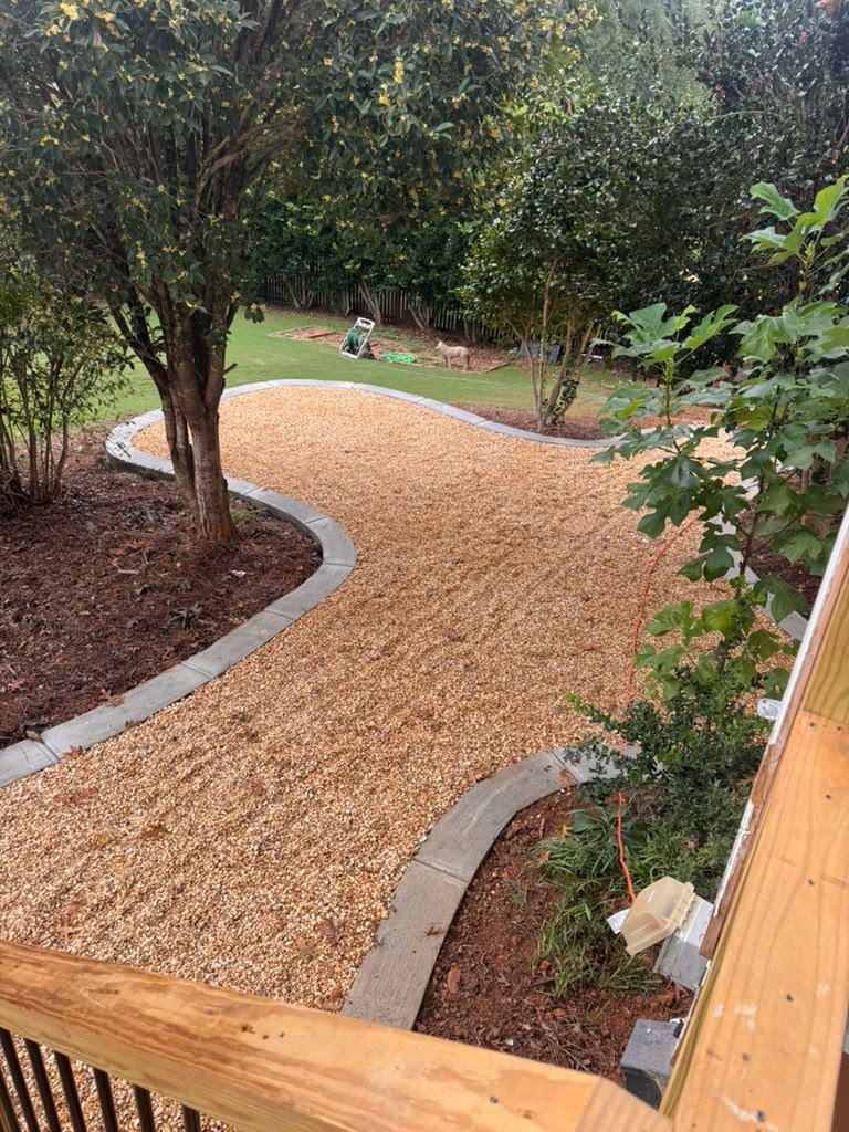 Curved pea gravel pathway with concrete edging and mulched planting beds