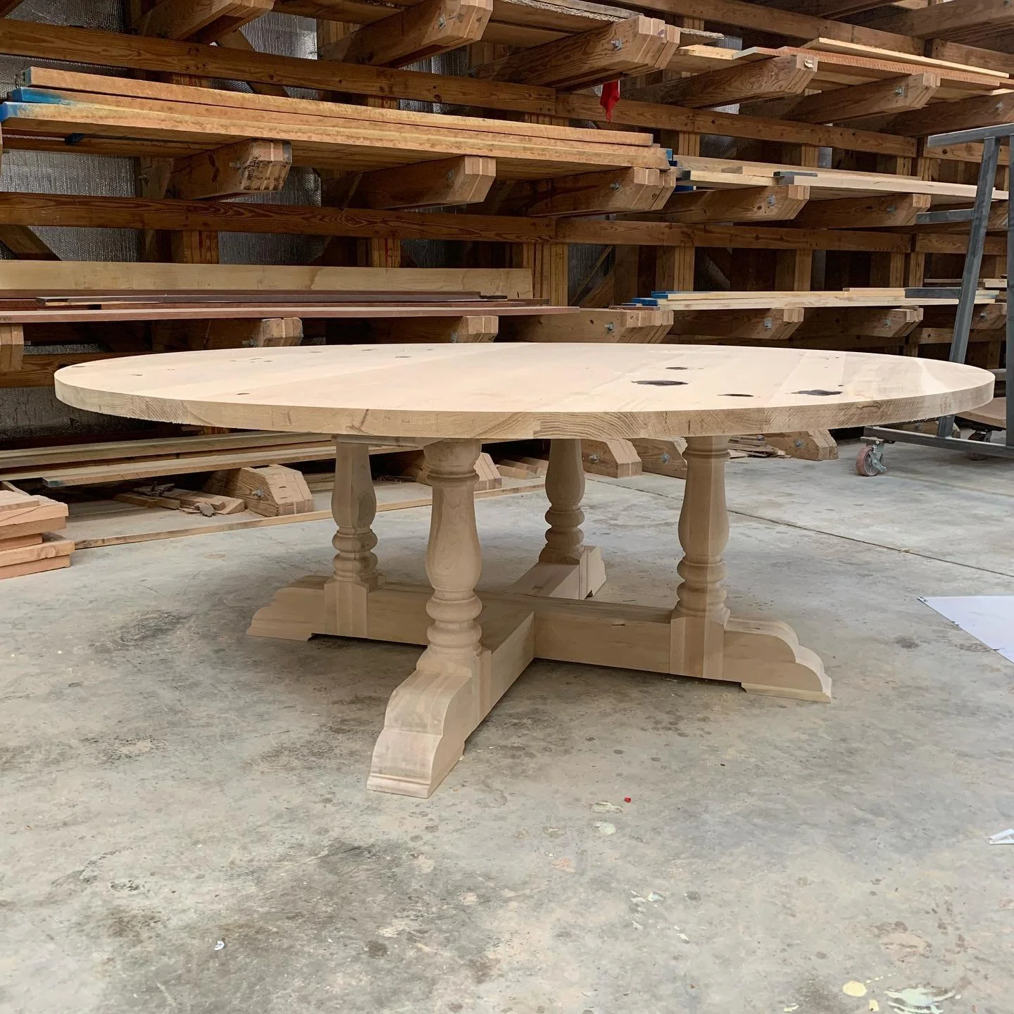 Unstained round wood table in the workshop, work in progress.