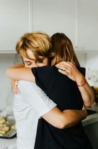 LGBTQ+ person telling mom about homophobia and being hugged by mom in Minneapolis.