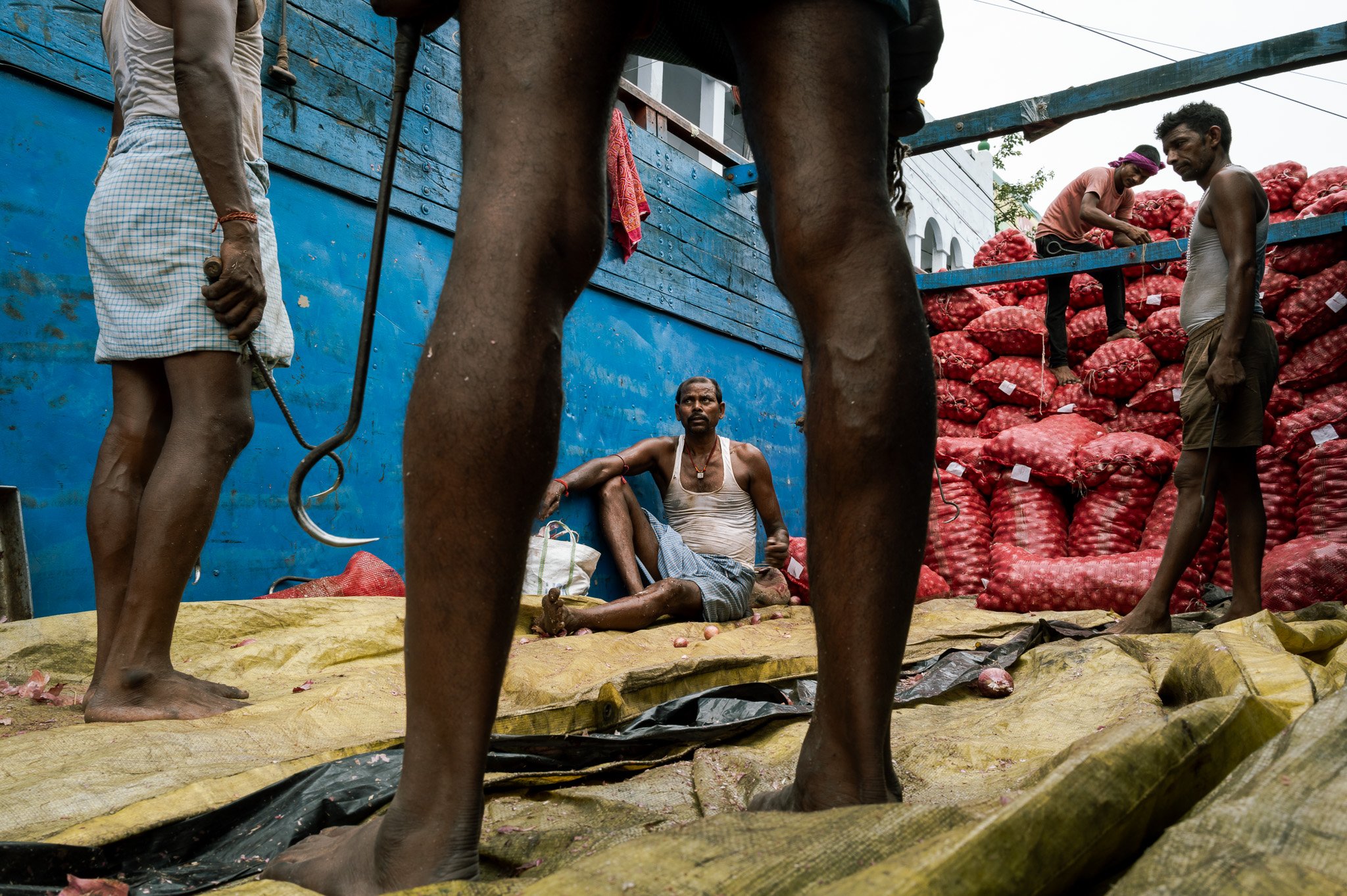 Kolkata Onion Market. Men resting who have been carrying onions. 