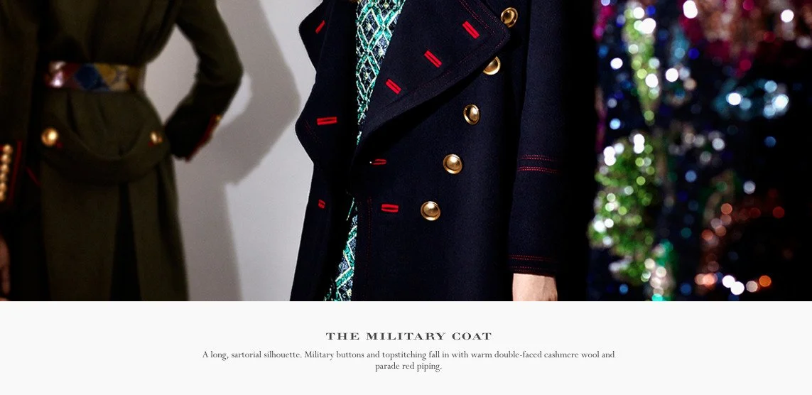 Close-up of a person wearing a dark navy military coat with gold buttons and red piping, standing beside a decorated Christmas tree.