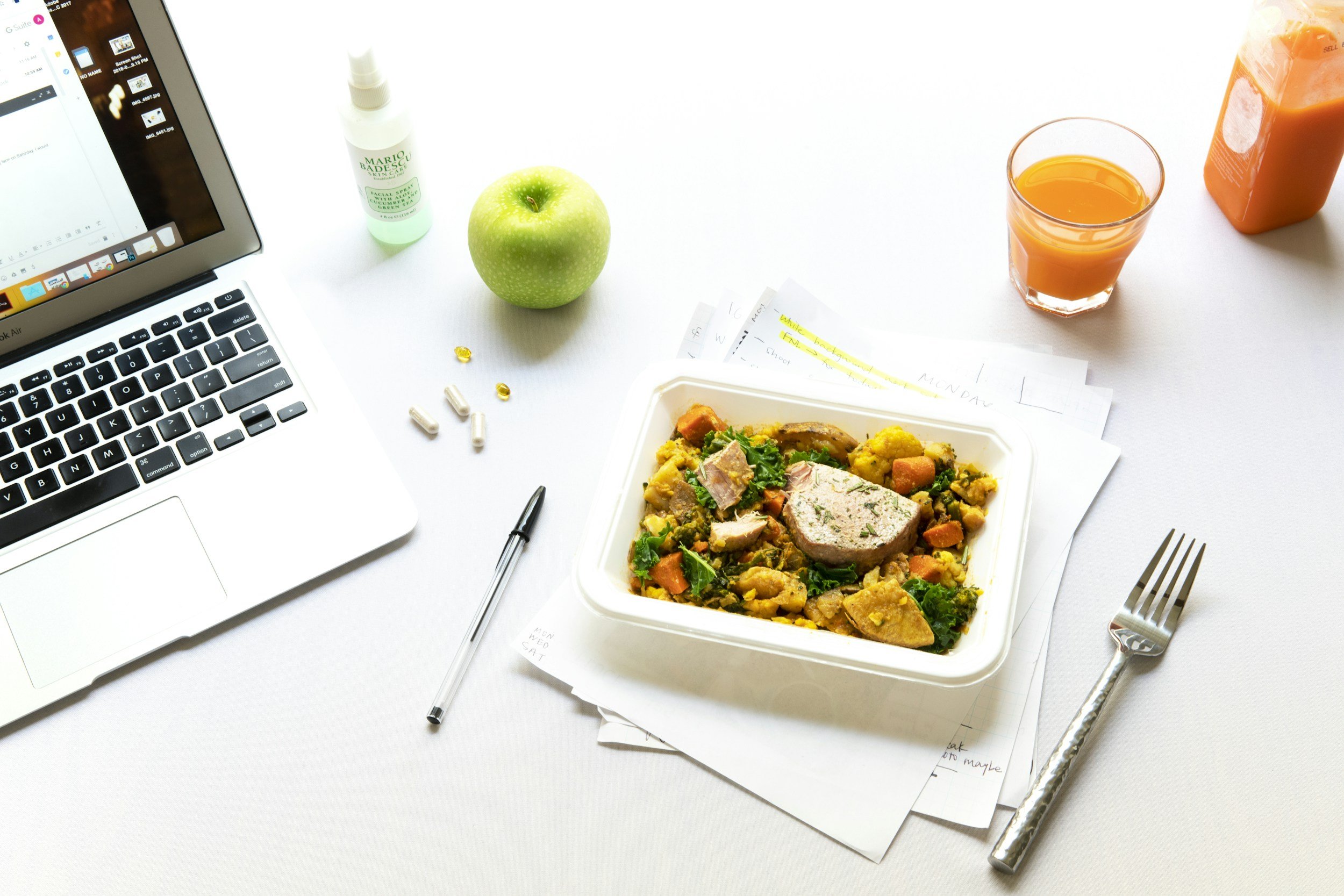 A person taking a lunch break beside a closed laptop.