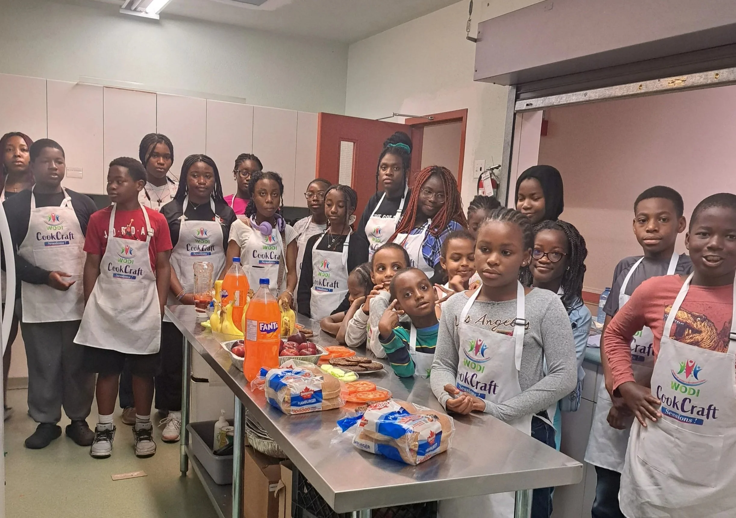 Youth that participated in the Cook Craft Culinary Camp posing together in matching aprons