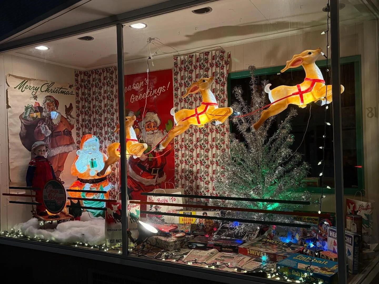 We went back with no glare to take detailed window photos. In our holiday-themed window the blow molds, posters, bags, boxes and tree are not for sale; just for seasonal enjoyment!  The vintage toys and games ARE for sale and we have posted a price l