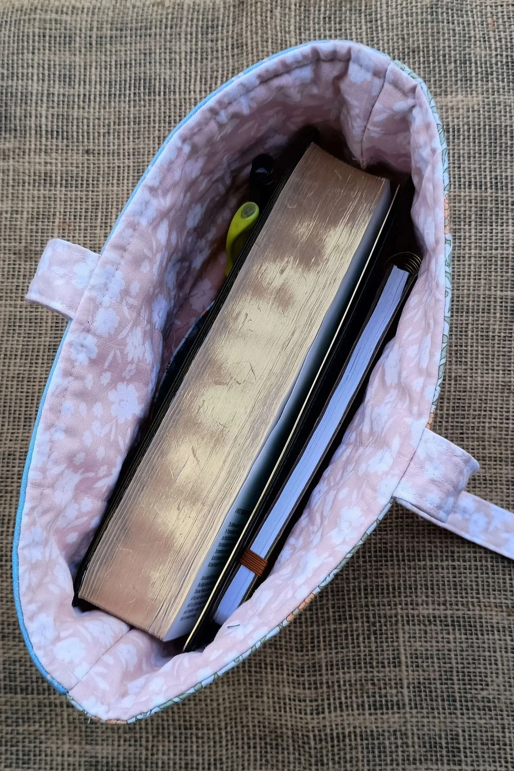 A quilted Bible Sleeve made from peach, green, and blue floral fabrics