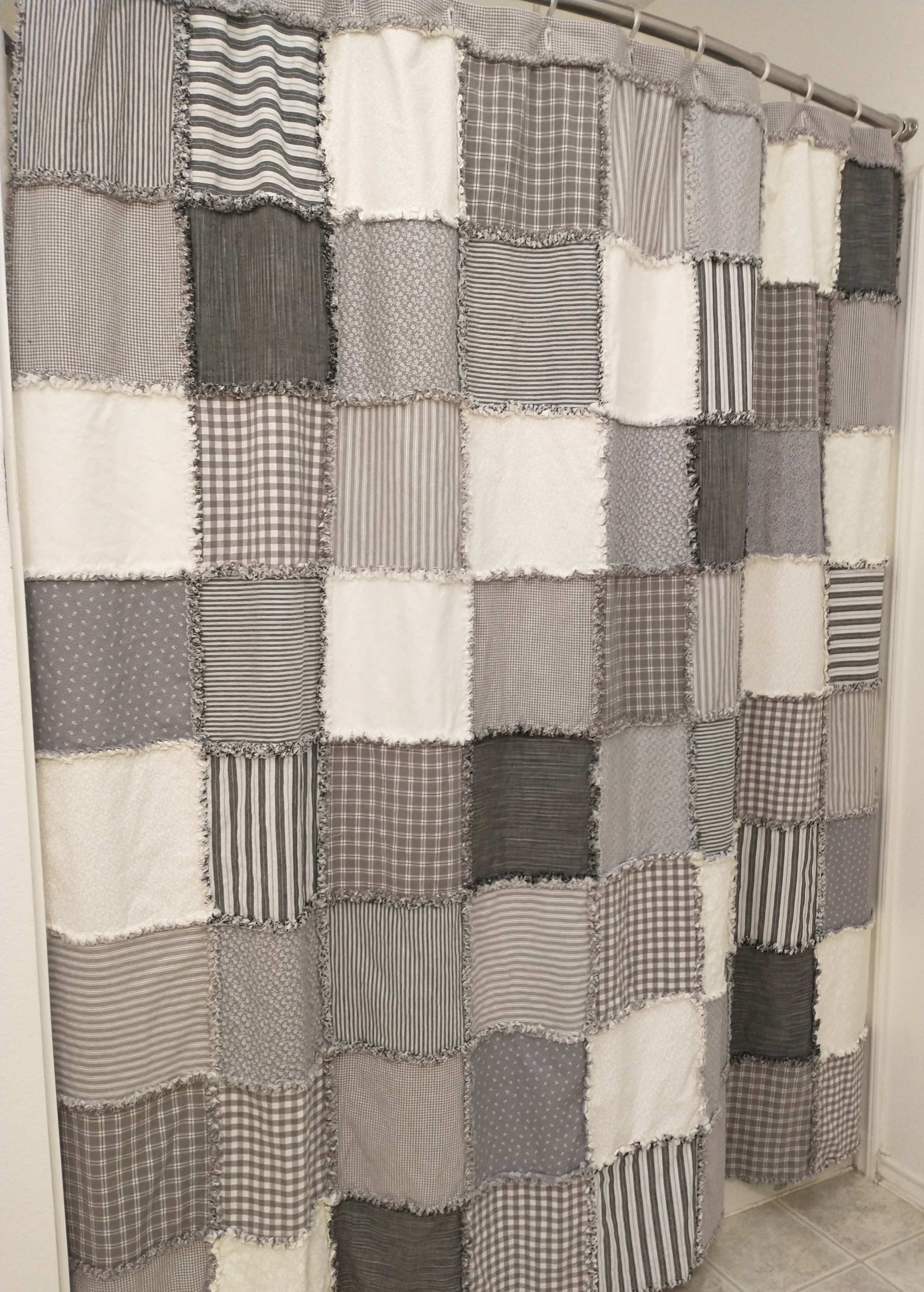 Contemporary style blends with farmhouse charm in this Patchwork Shower Curtain in Gray and Cream.