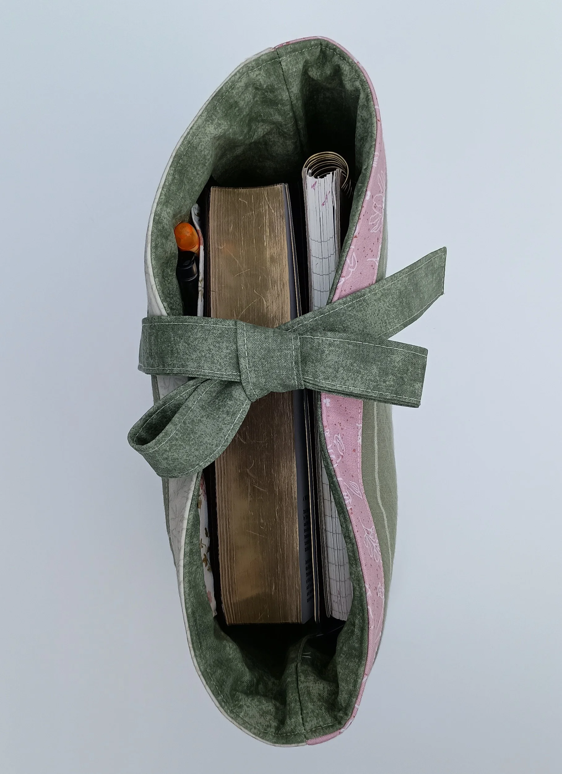 A quilted Bible Sleeve made from sage, pink, and beige fabrics